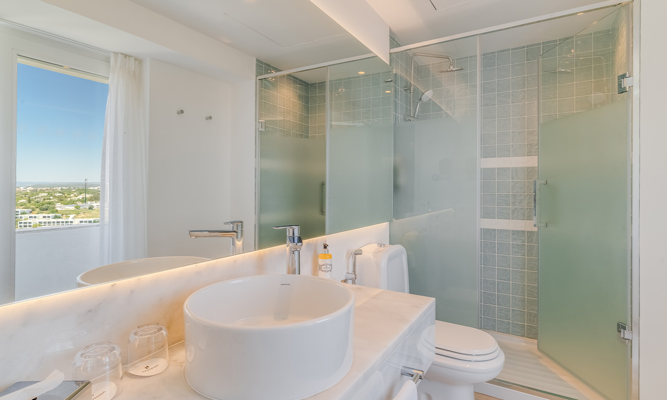 La Chambre Classique Vue Jardin du Pestana Blue Alvor Beach a une Salle de Bain avec Lavabo avec Miroir, WC et Douche