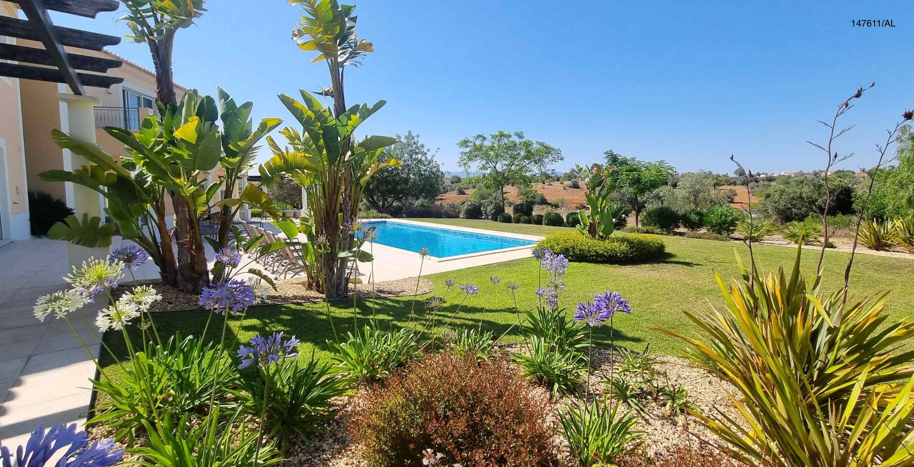 La villa Pestana Carvoeiro Golf V5 Superior dispose d'un espace extérieur avec une piscine, une pelouse et des arbres autour