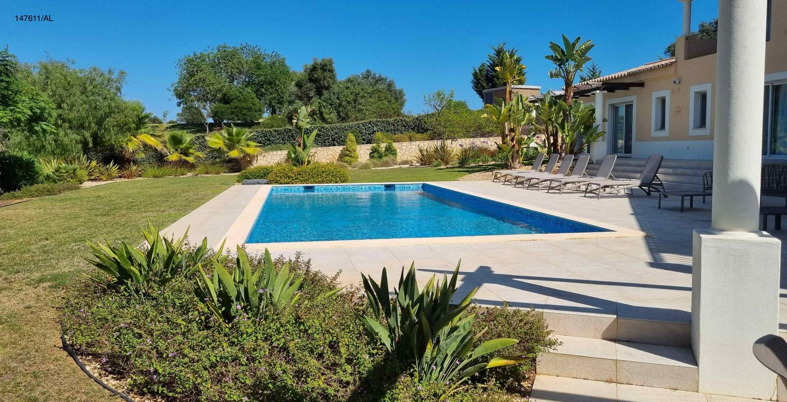 La villa Pestana Carvoeiro Golf V5 Superior dispose d'un espace extérieur avec une piscine une pelouse et des chaises longues