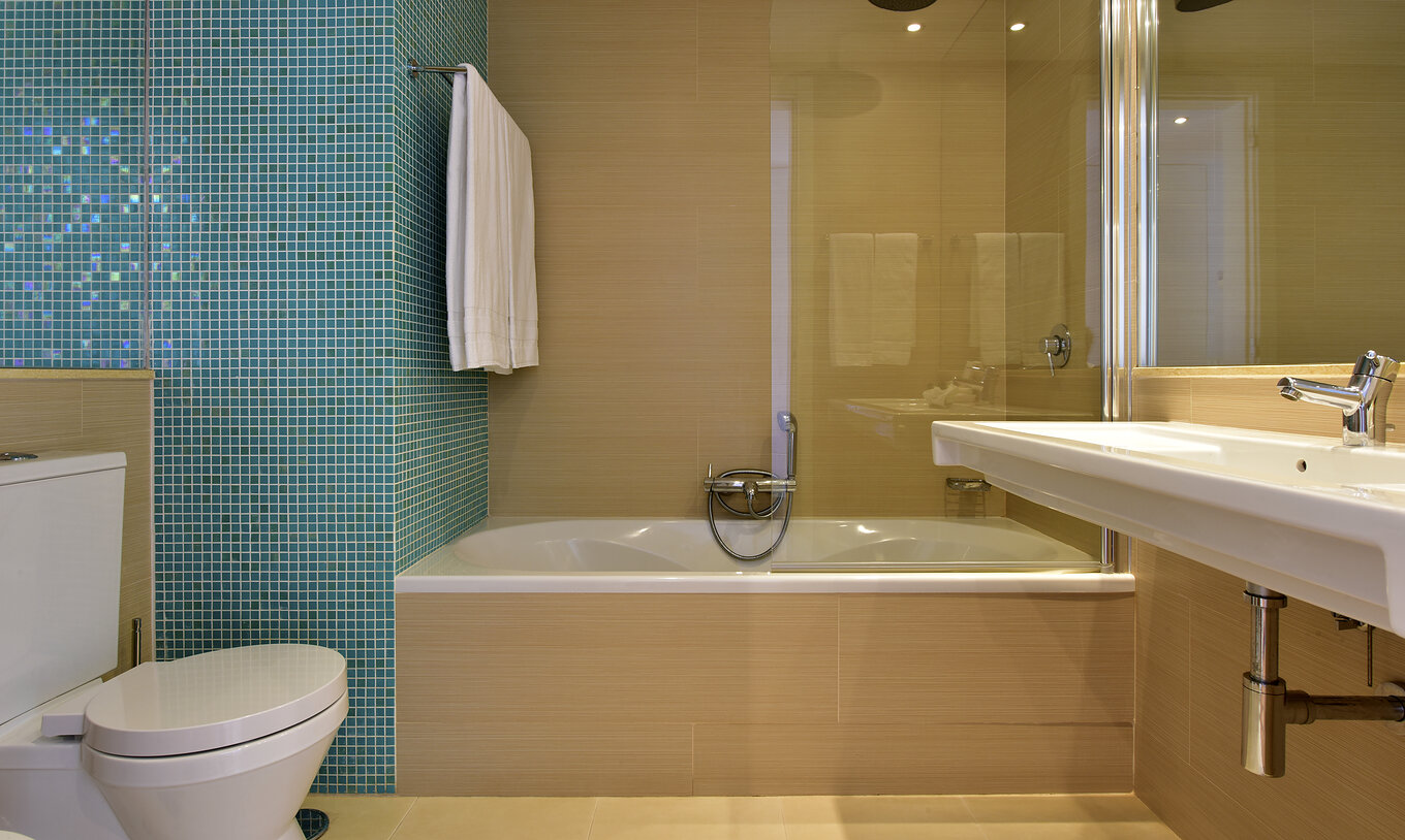 La Suite Standard du Pestana Dom João II a une salle de bain avec lavabo, miroir et baignoire avec douche