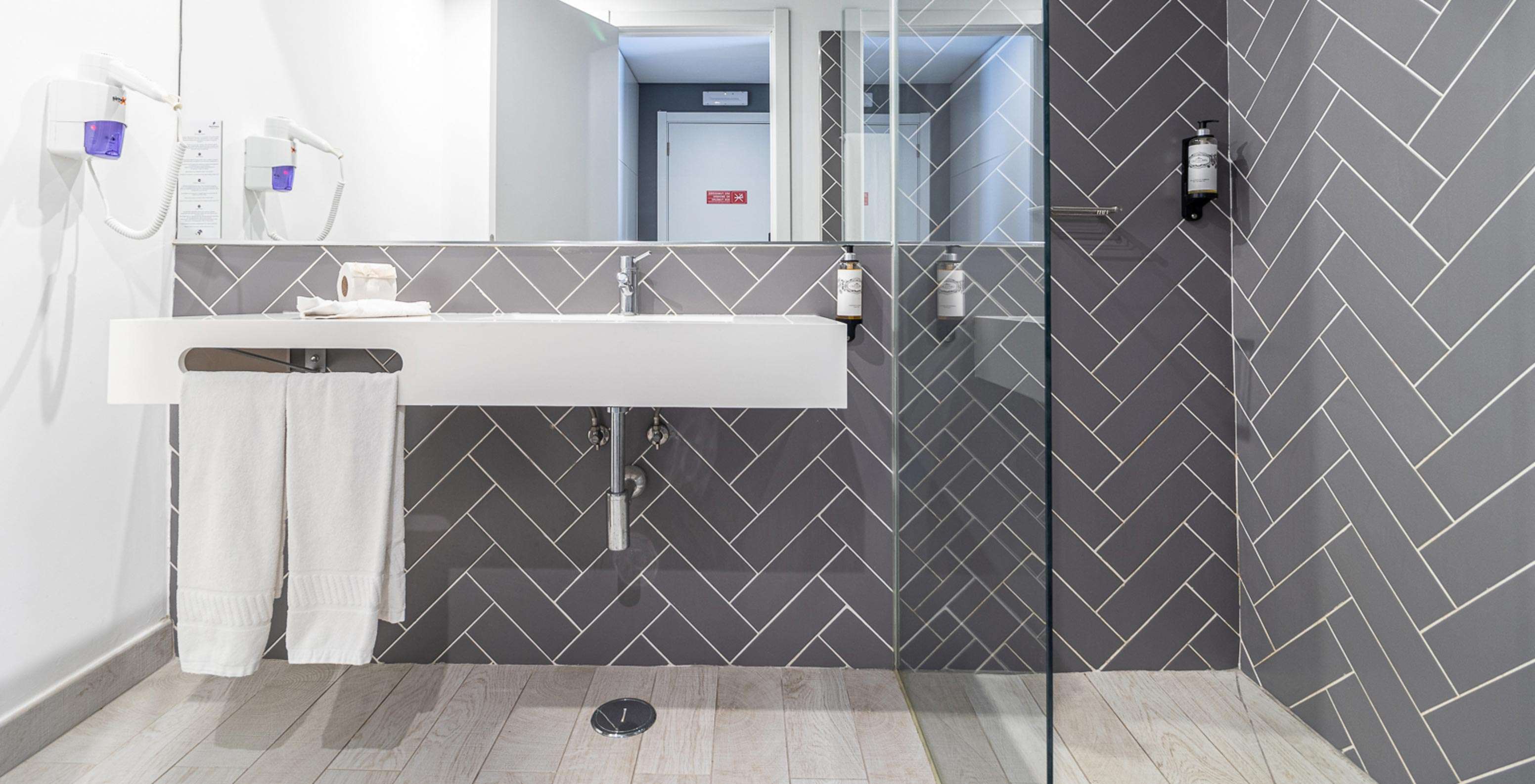 Chambre Classique au Pestana Gramacho Residences avec salle de bain moderne, lavabo blanc, miroir, douche vitrée