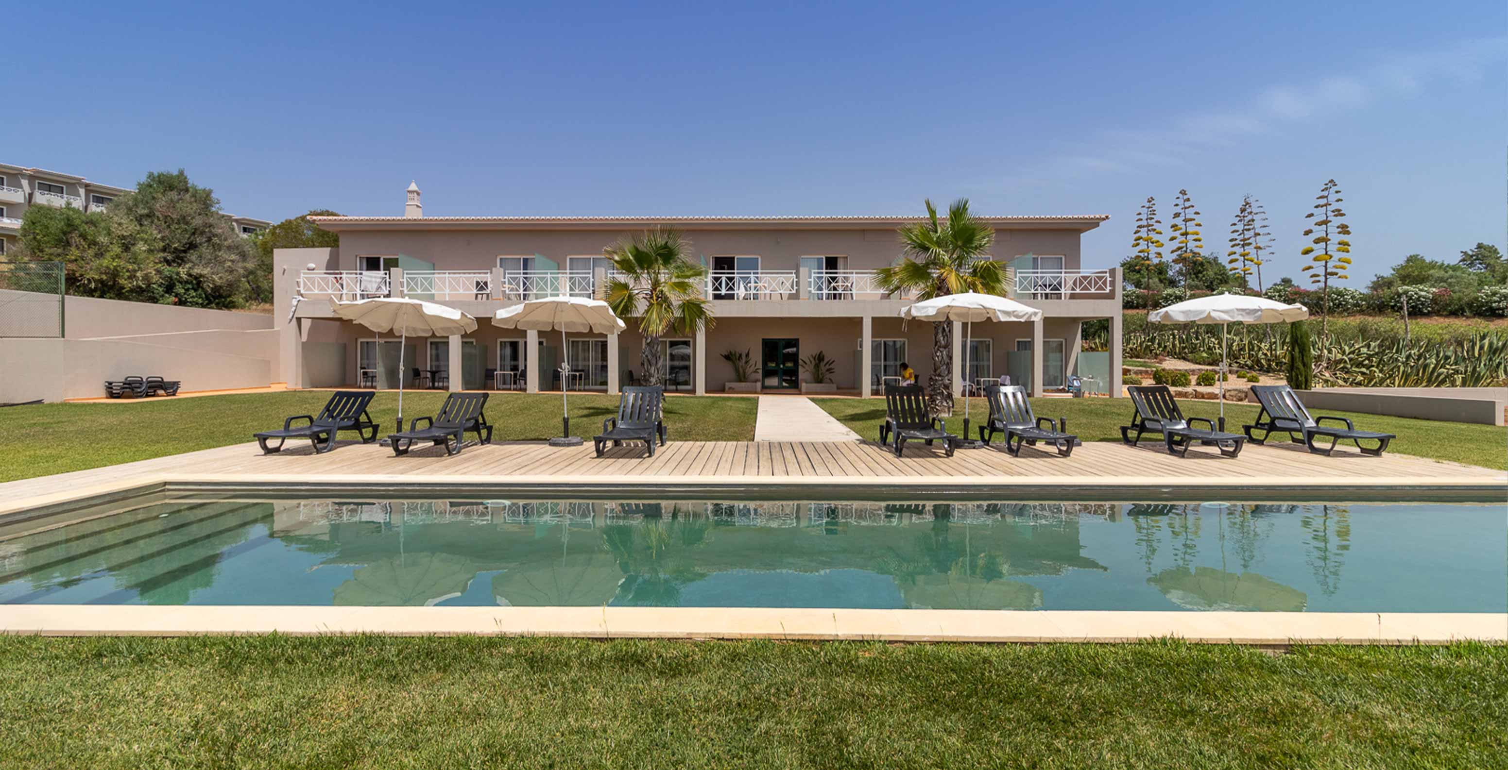 Chambre Classique au Pestana Gramacho Residences avec piscine, transats et parasols dans un jardin soigné