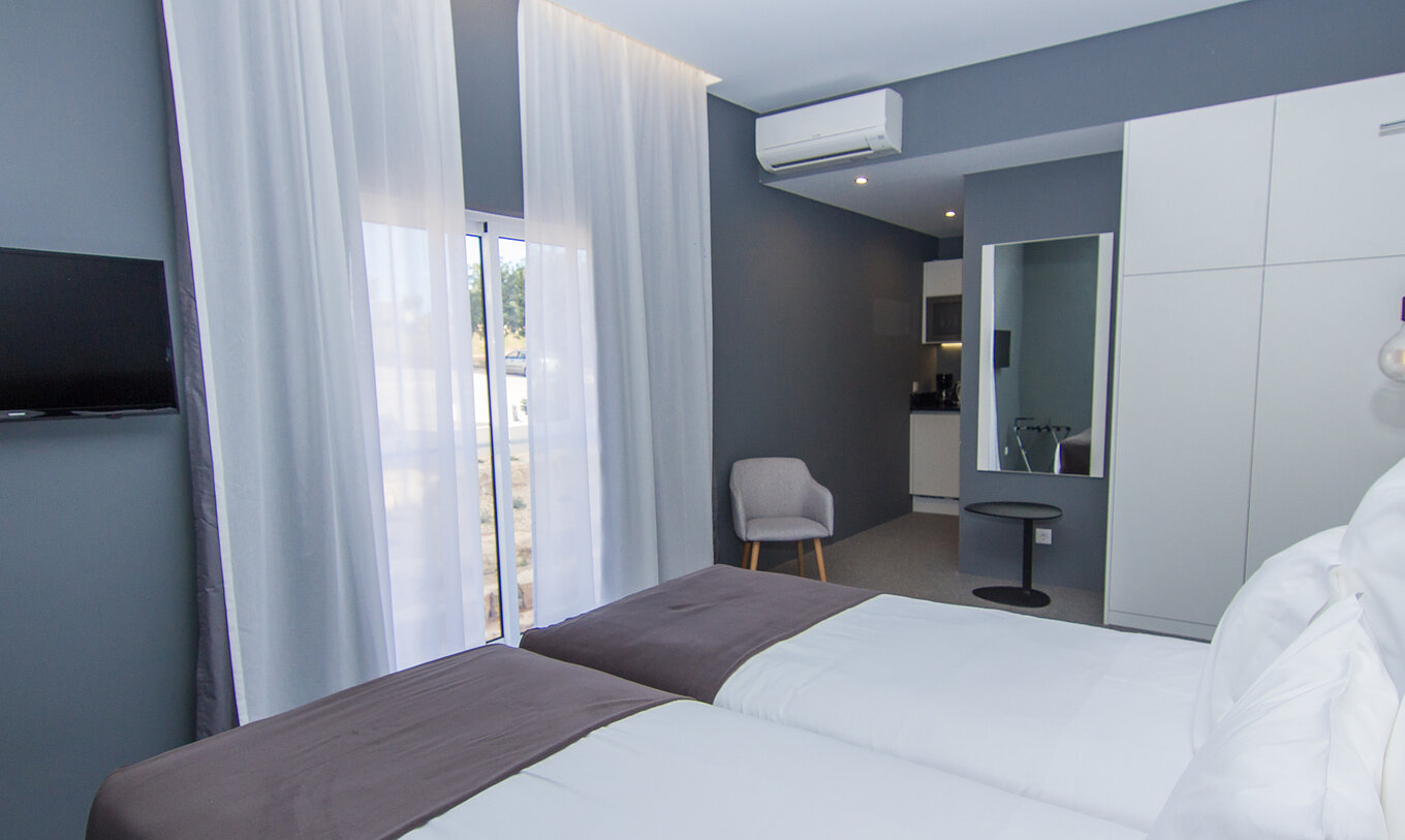 La chambre Classique du Pestana Gramacho Residences a deux lits simples, climatisation, une fenêtre et un miroir