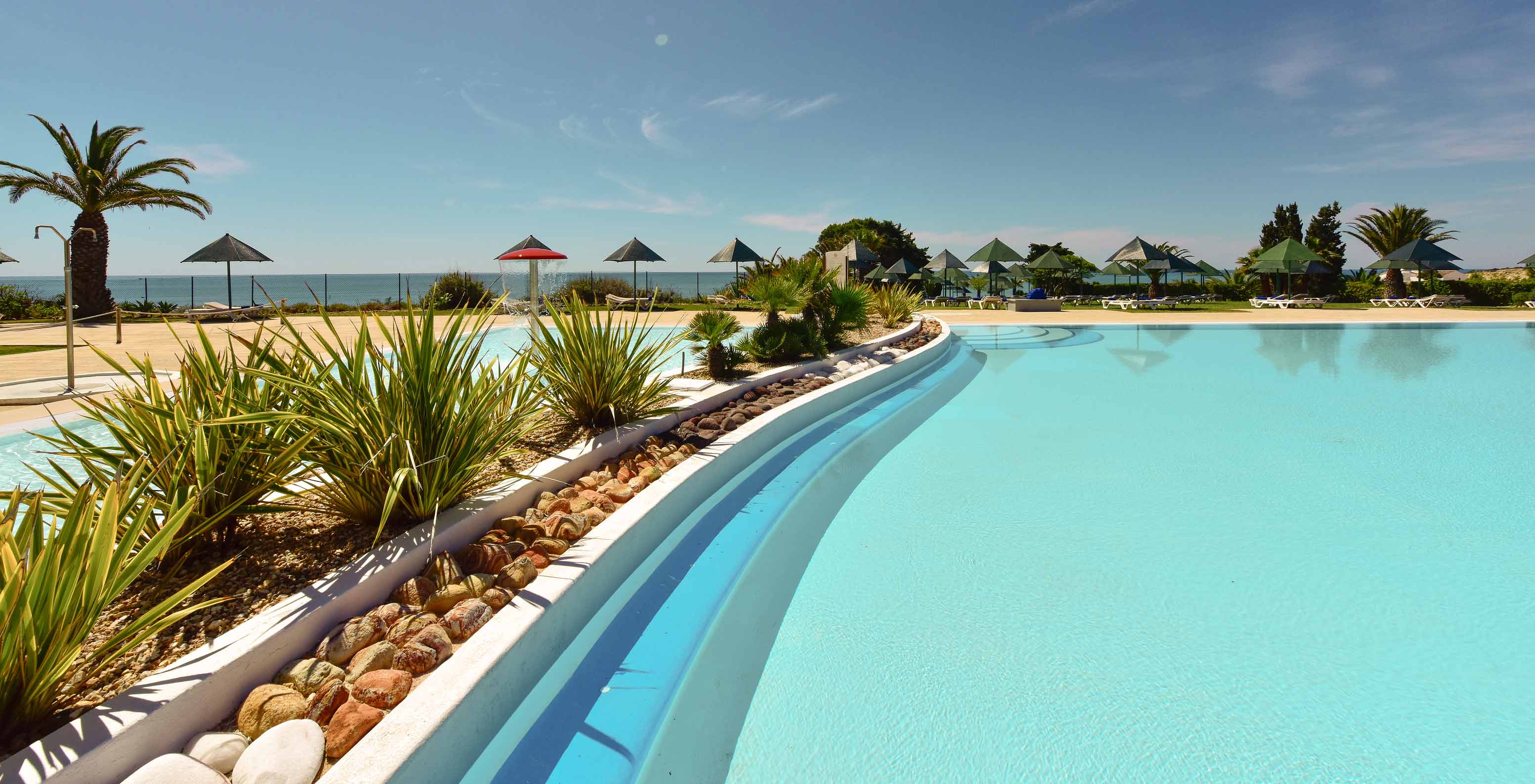 Piscine extérieure du Pestana Viking, entourée de végétation, avec transats et vue sur la mer