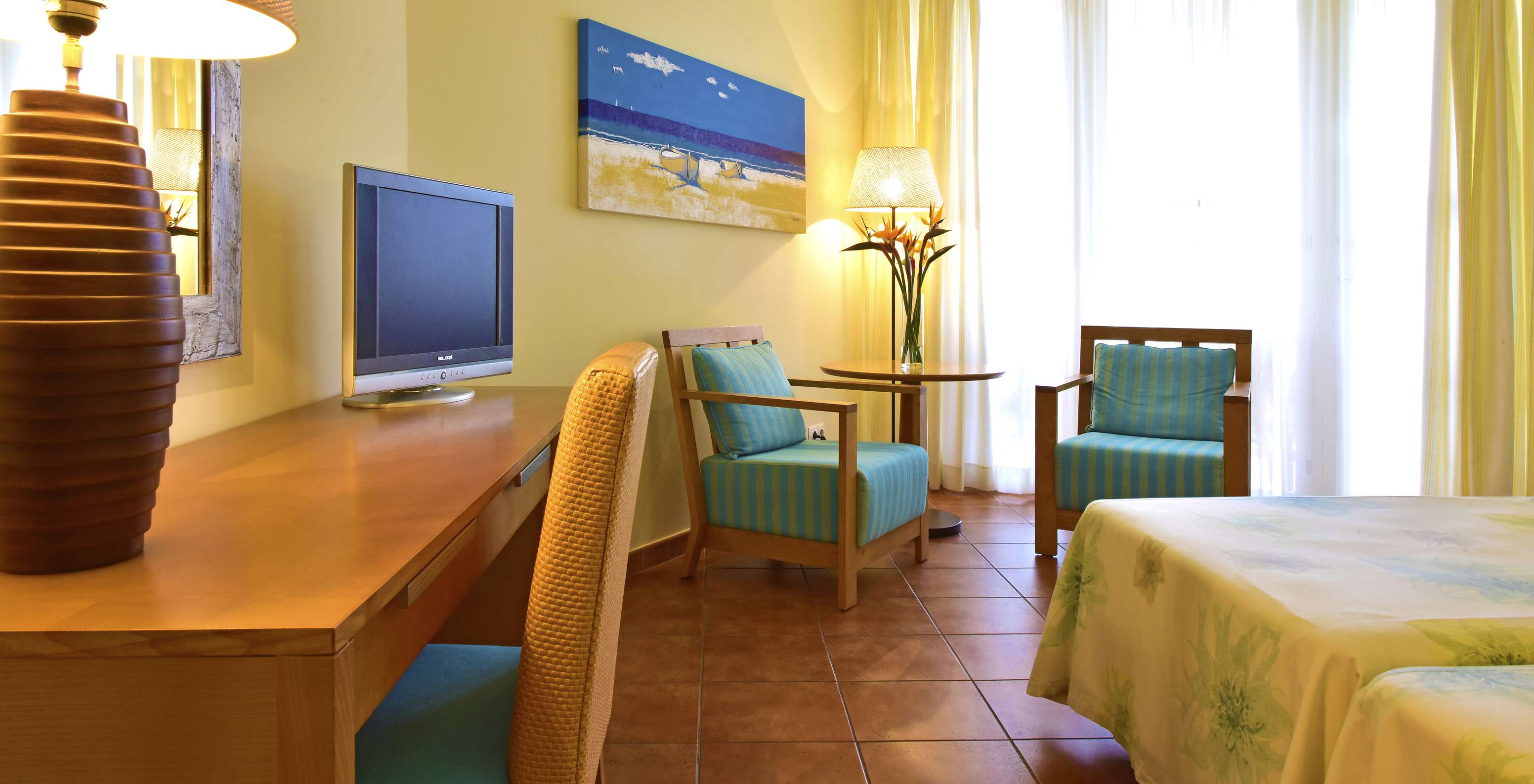 Le Chambre Deluxe Supérieur Vue Mer du Pestana Viking comprend télévision, deux chaises avec table basse, et un bureau