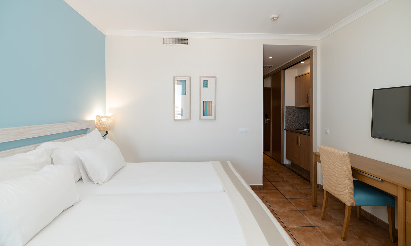 Le Deluxe Vue Mer Latérale du Pestana Viking a deux lits, une télévision et une petite cuisine