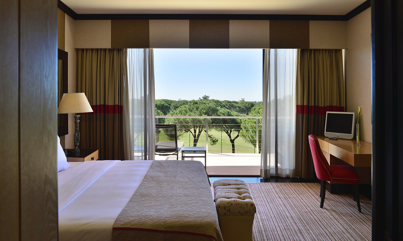 La Suite Présidentielle du Pestana Vila Sol - Vilamoura a un lit, bureau et un balcon avec vue sur le jardin