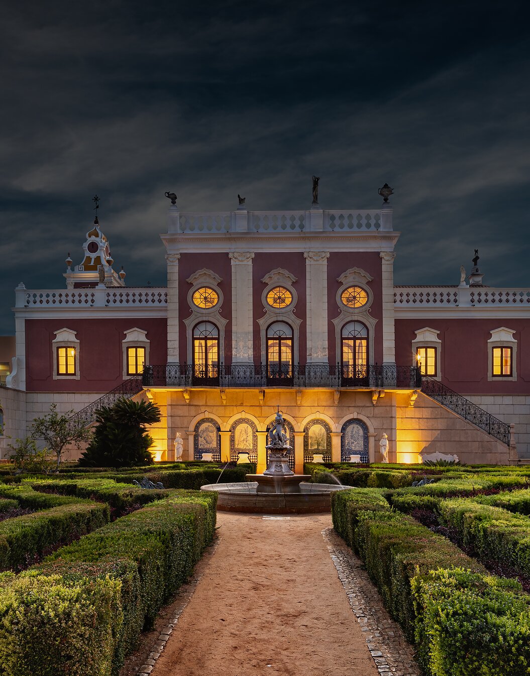 Vue nocturne de l'hôtel historique à Faro, Pousada Palácio do Freixo, avec jardins et une fontaine illuminée