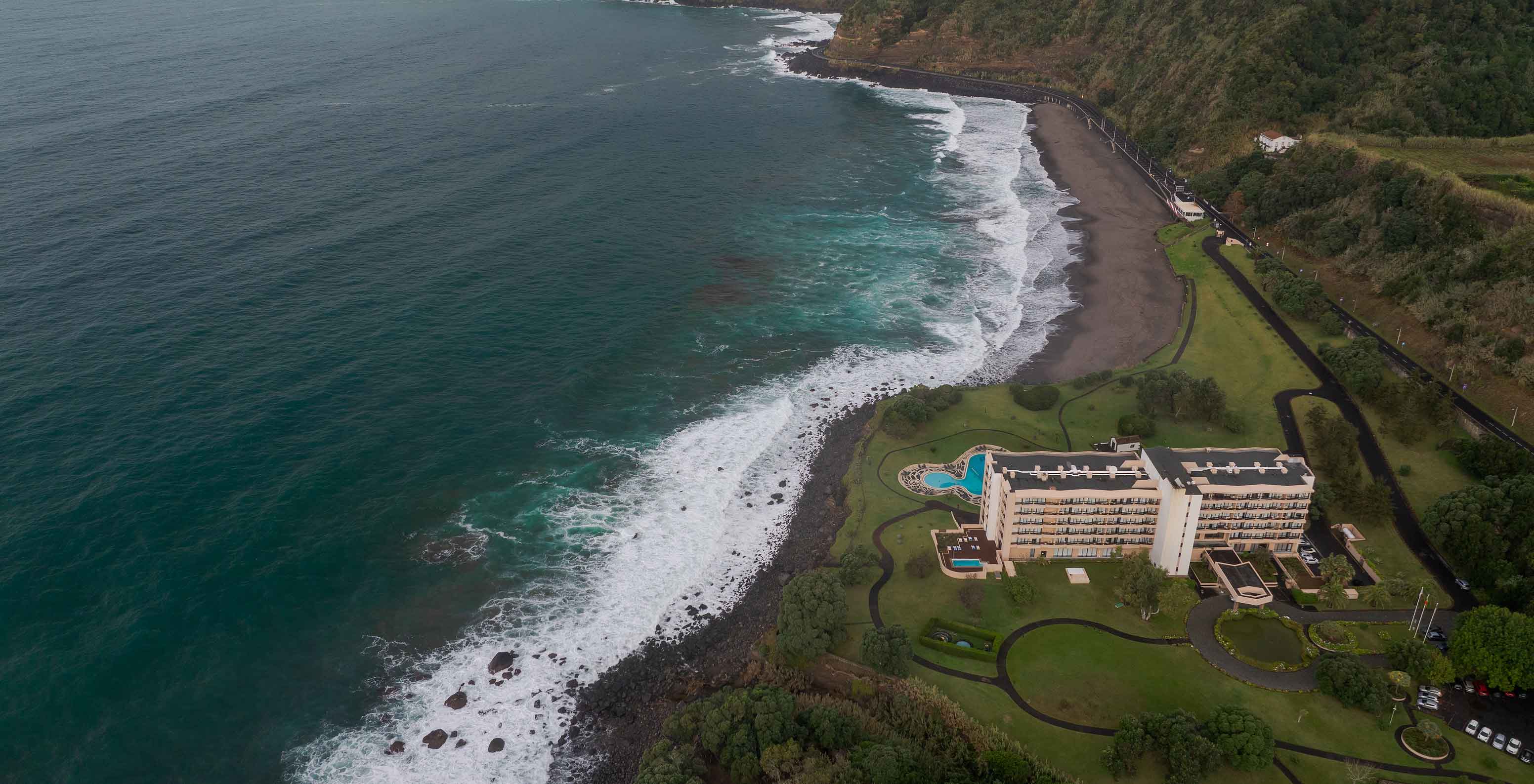 Vue aérienne du Pestana Bahia Praia près de la côte avec plage, vagues et végétation verte autour