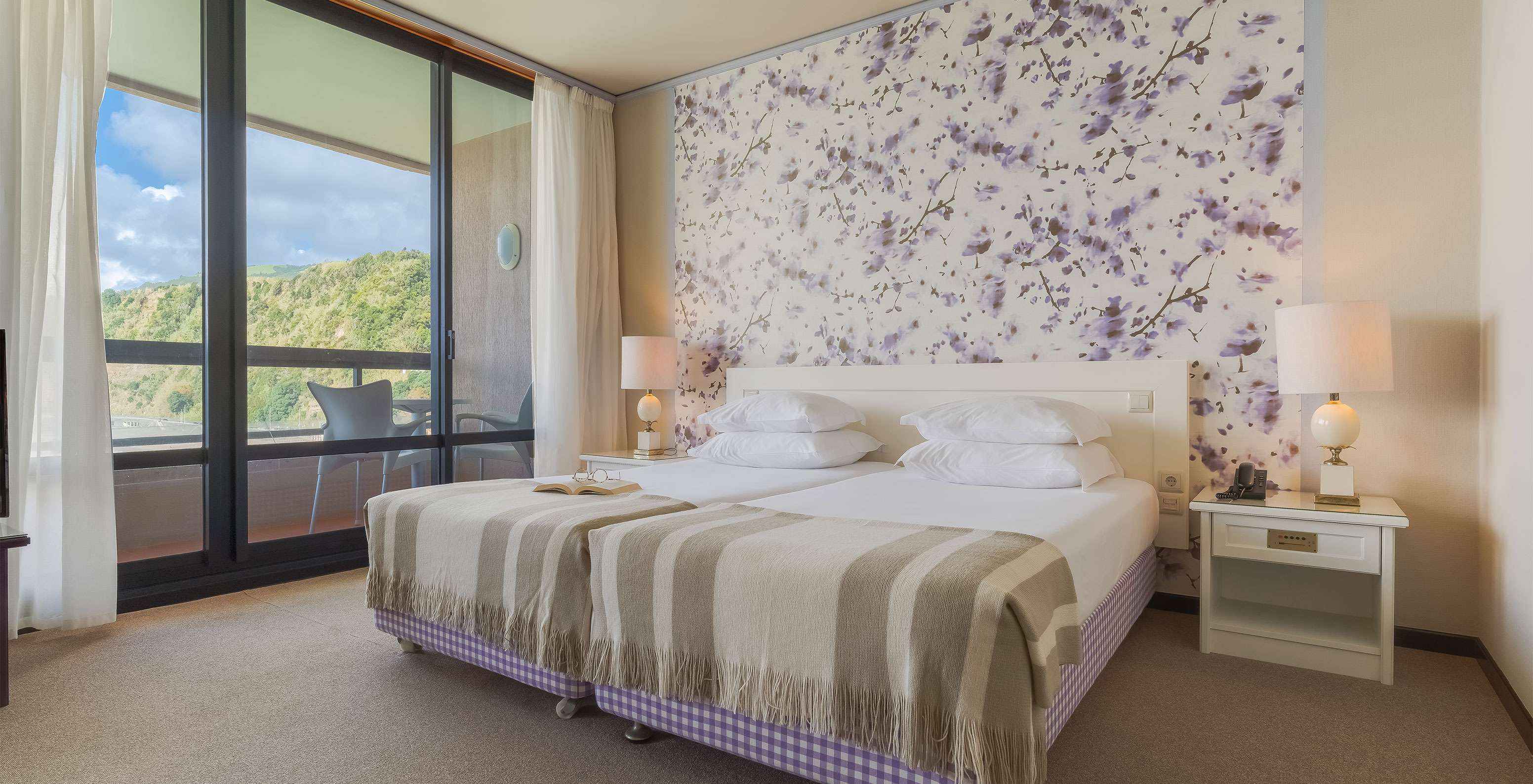 La Junior Suite Vista Mar du Pestana Bahia Praia a un grand espace avec deux lits individuels et un canapé et une chaise