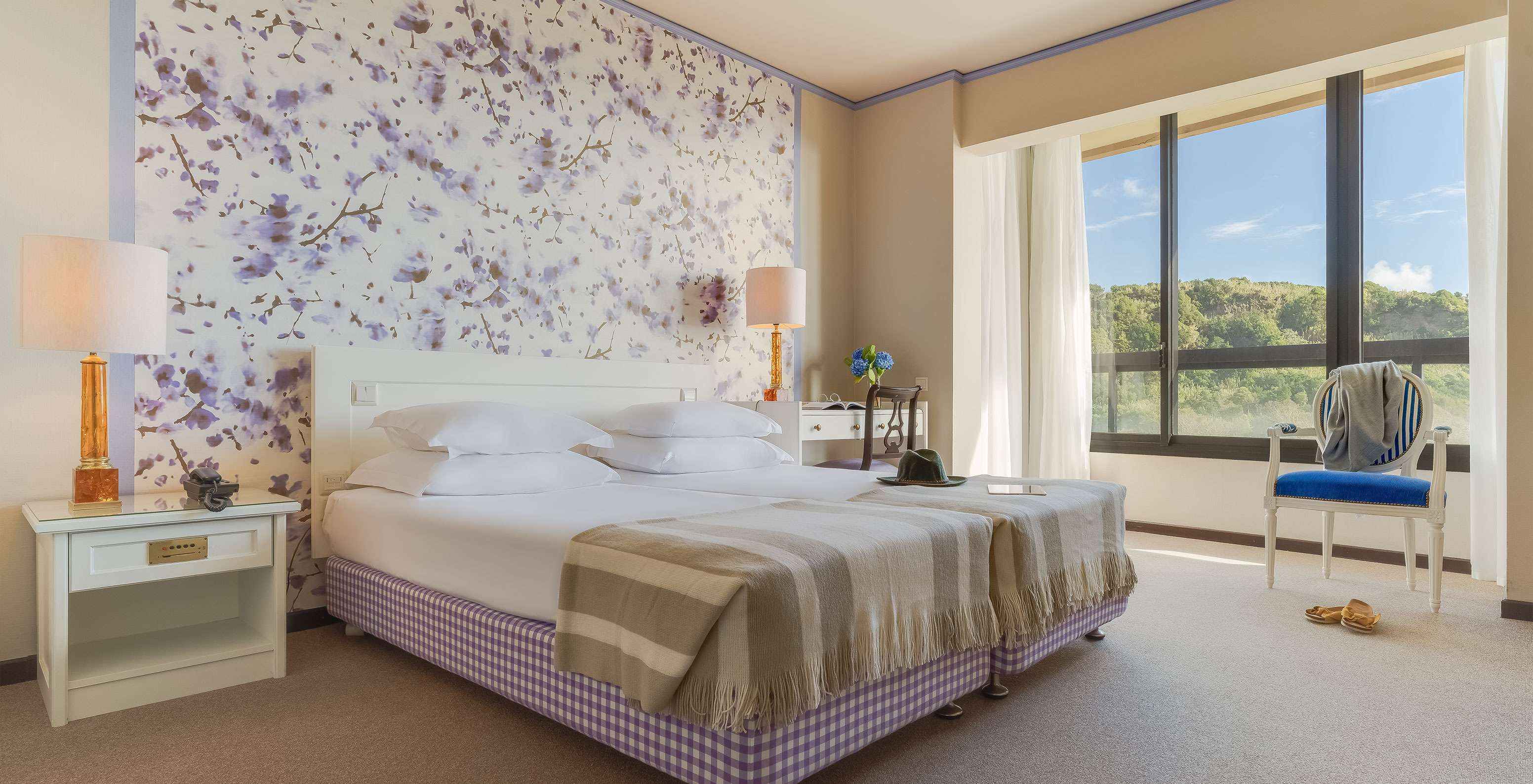 Le Standard Vista Jardim du Pestana Bahia Praia est une chambre spacieuse avec deux lits une table de chevet et un bureau