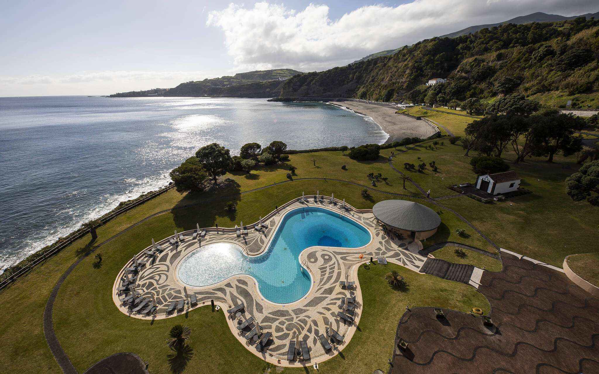 Piscine avec vue sur la mer et la plage au Pestana Bahia Praia à São Miguel par temps partiellement nuageux