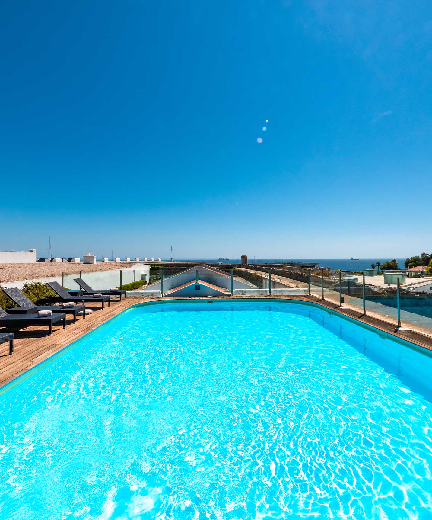 Piscine extérieure avec chaises longues dans un hôtel 5 étoiles à Cascais, avec vue sur la mer