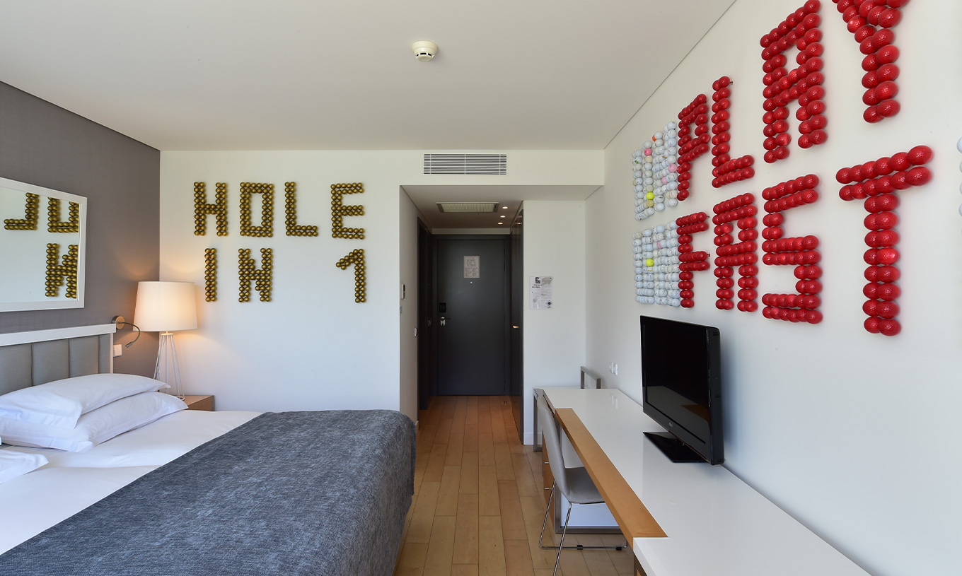 La Chambre Superior avec Balcon du Pestana Cidadela Cascais a un couloir à l'entrée, une télévision et de l'art sur deux murs