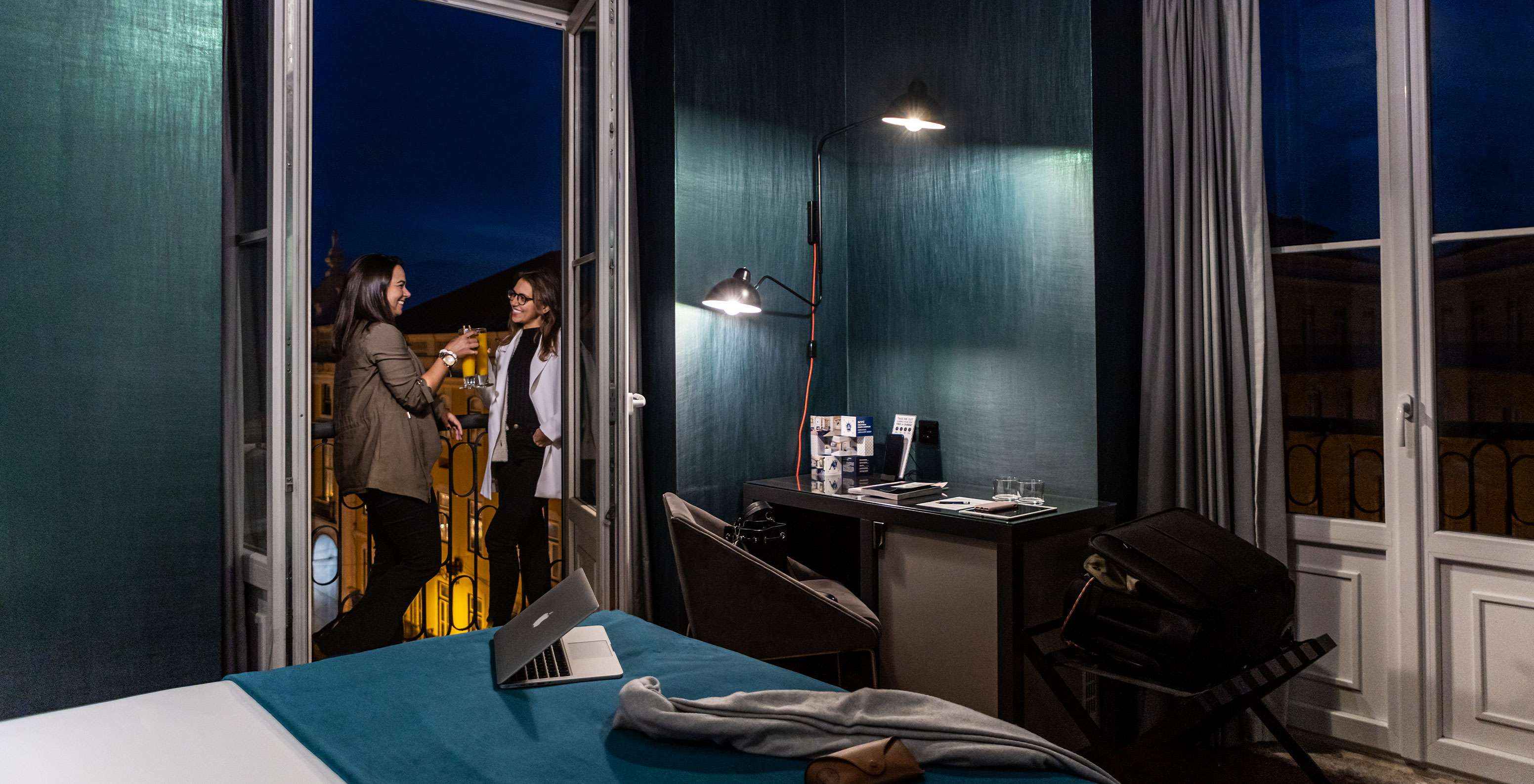 Dans la chambre CR7 Superior Corner du Pestana CR7 Lisboa, profitez d'une boisson sur le balcon avec vue sur la ville