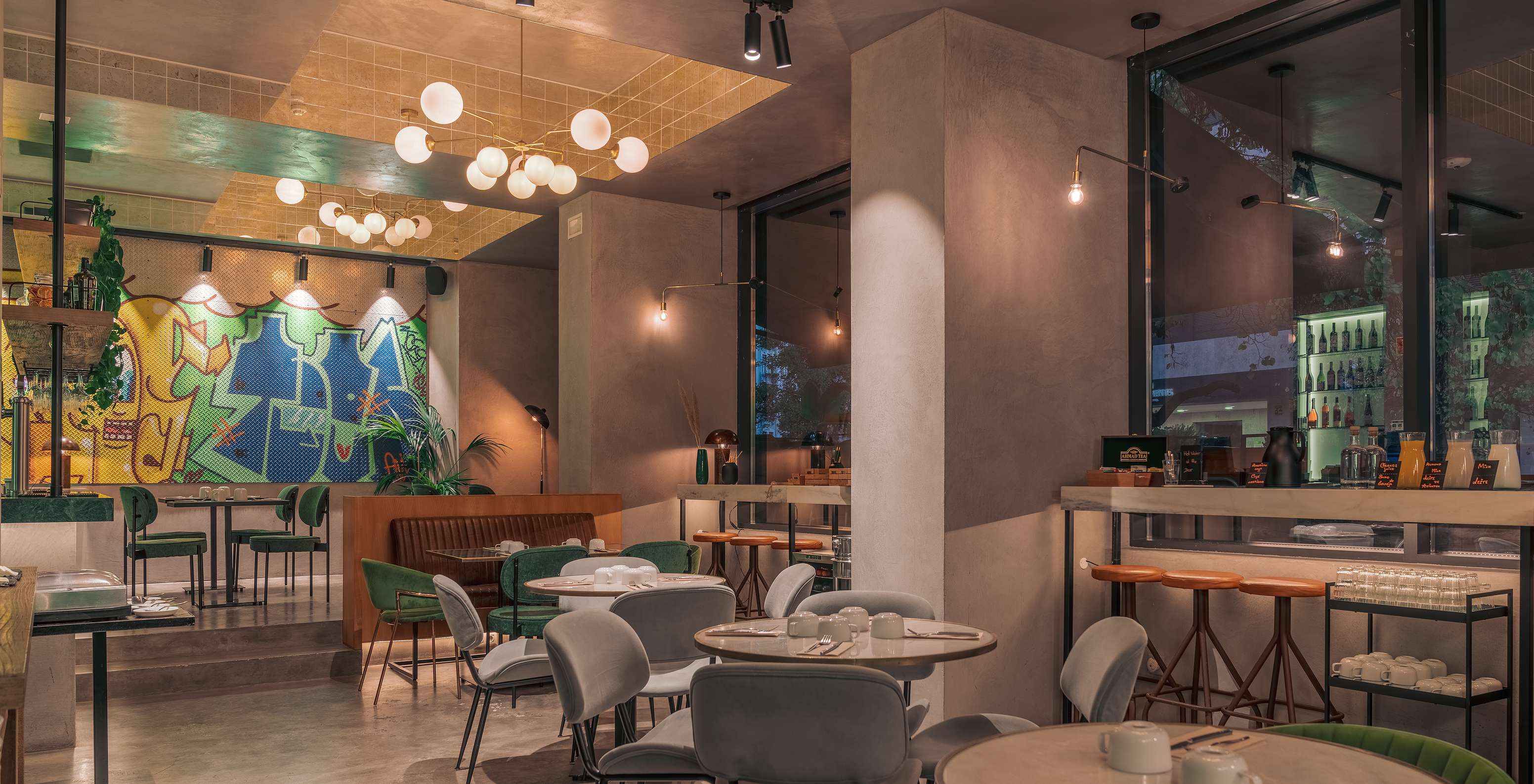 Restaurant du Pestana Lisboa Vintage avec tables et chaises colorées lampes de plafond et comptoirs hauts avec chaises