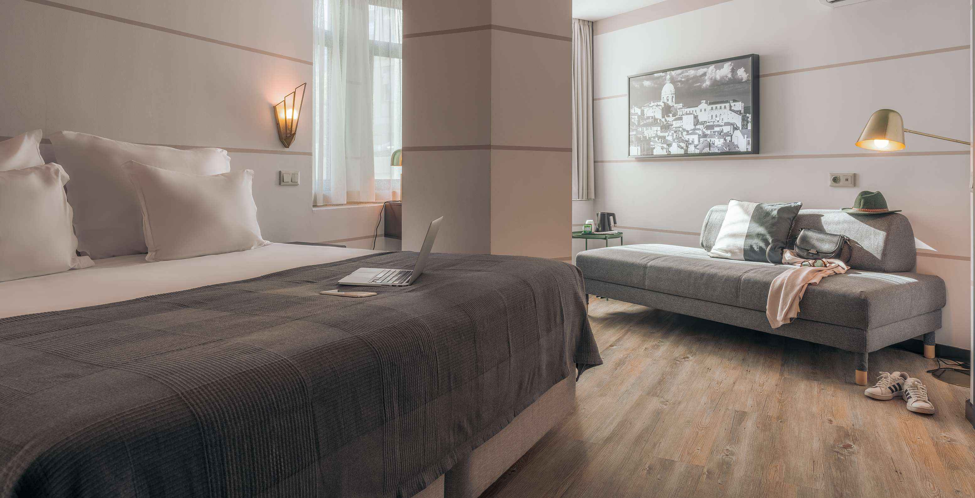 Le Double Supérieur du Pestana Lisboa Vintage a un lit double avec couverture grise un canapé gris et des baskets blanches