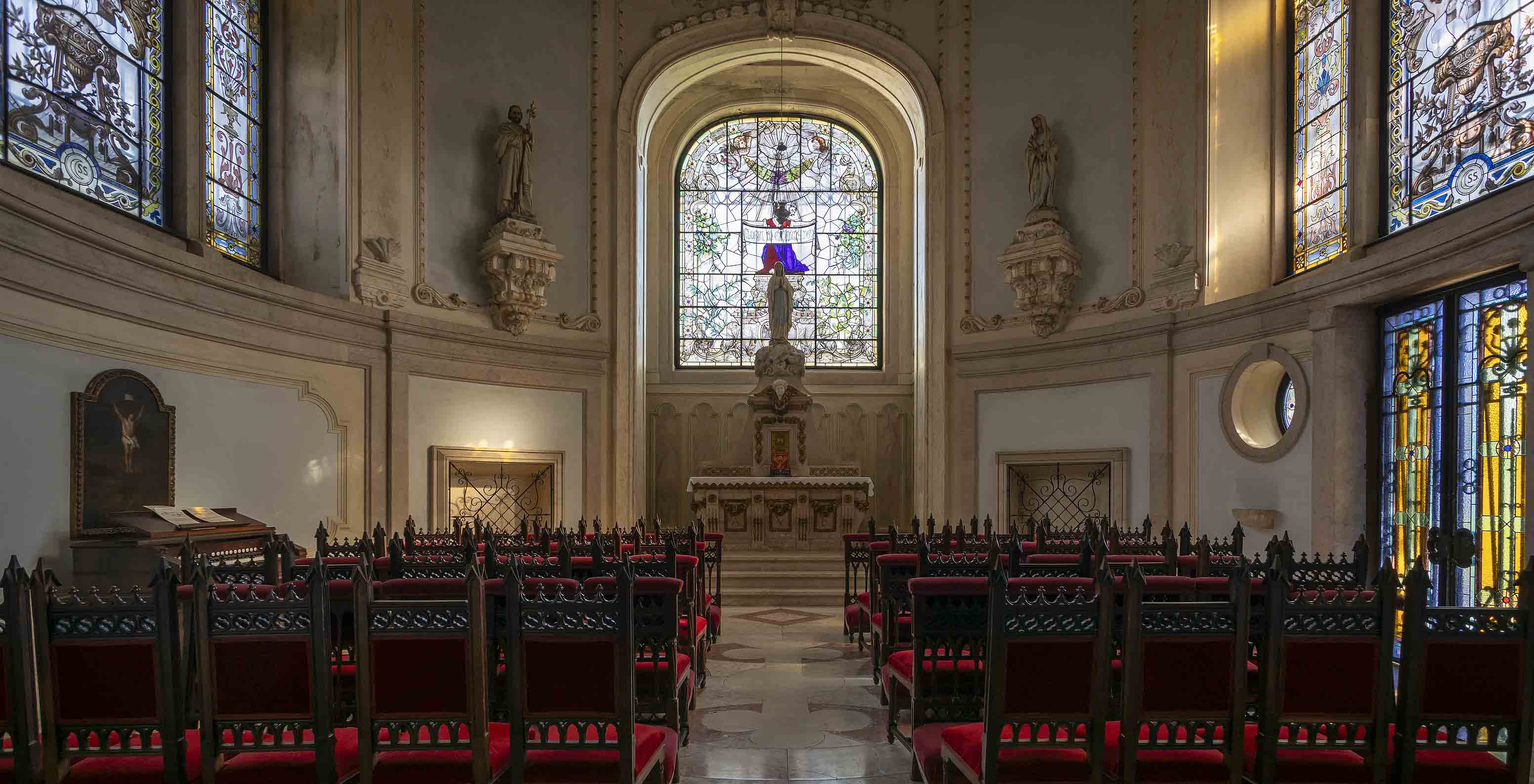 Le Pestana Palace Lisboa possède une chapelle avec un petit autel, plusieurs vitraux et des chaises en bois foncé