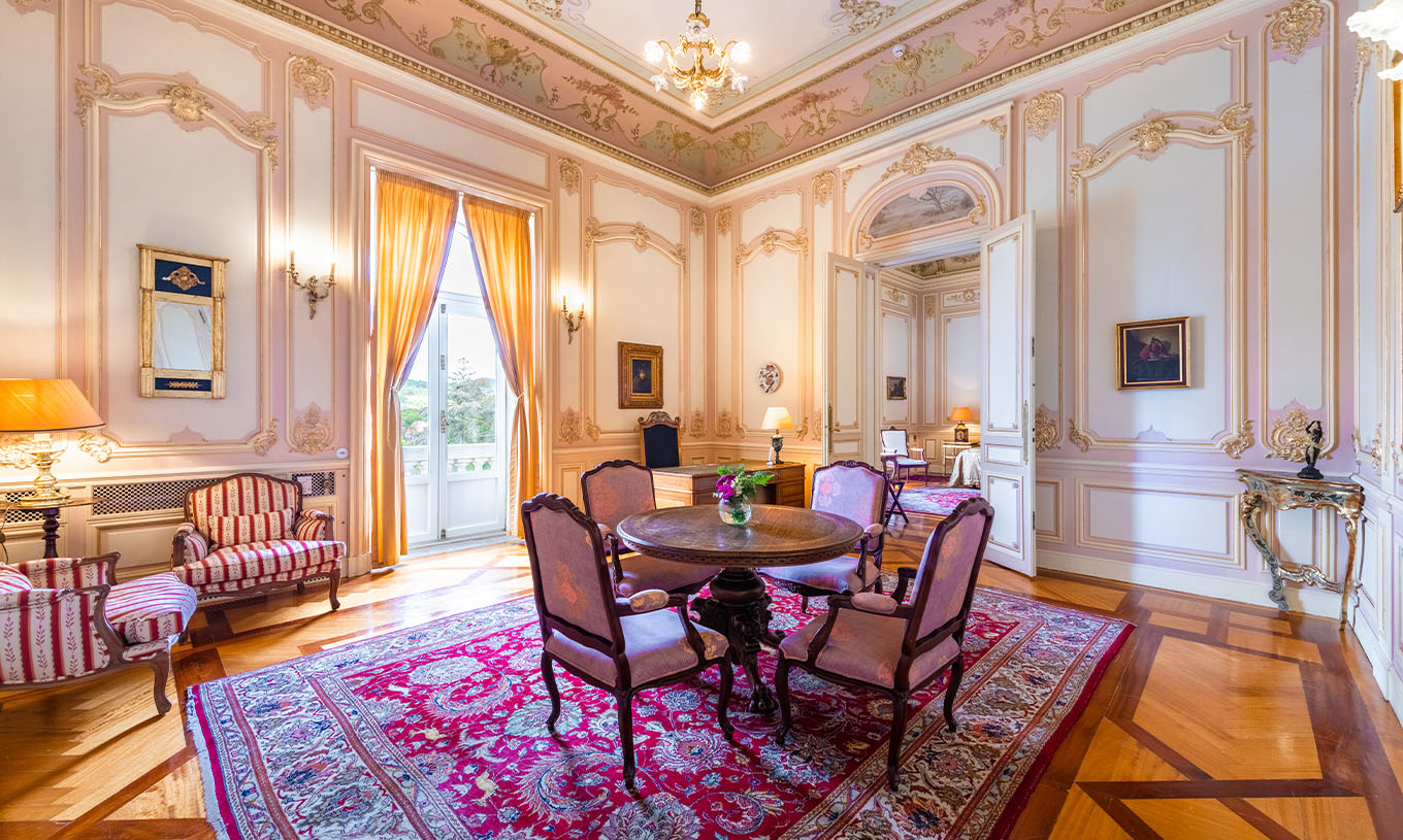La Suite D. Carlos du Pestana Palace Lisbonne a un grand et luxueux salon avec une fenêtre et une table pour les repas
