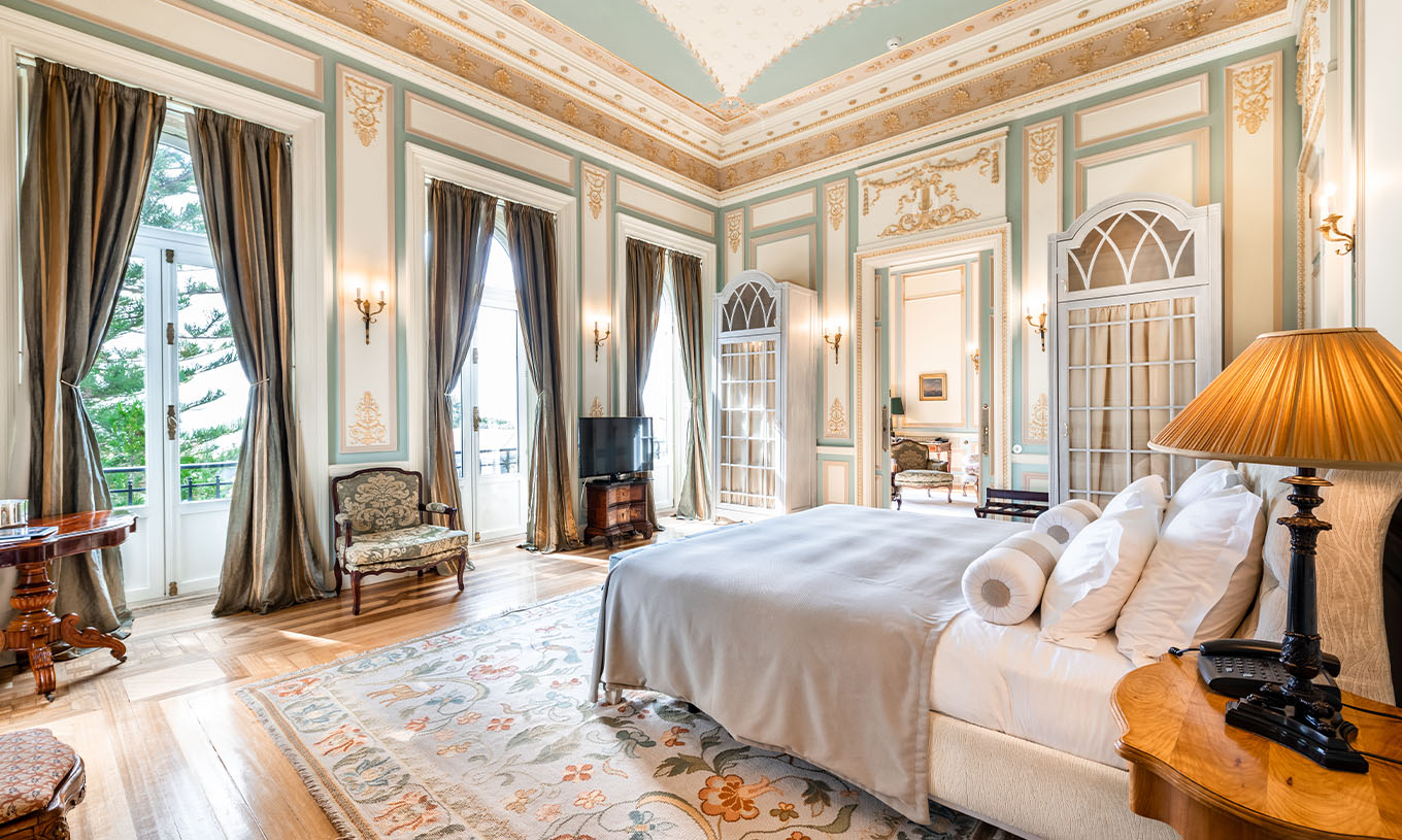 La Suite D. Manuel/ D. Luís Filipe du Pestana Palace Lisbonne a une grande chambre avec trois fenêtres donnant sur le jardin