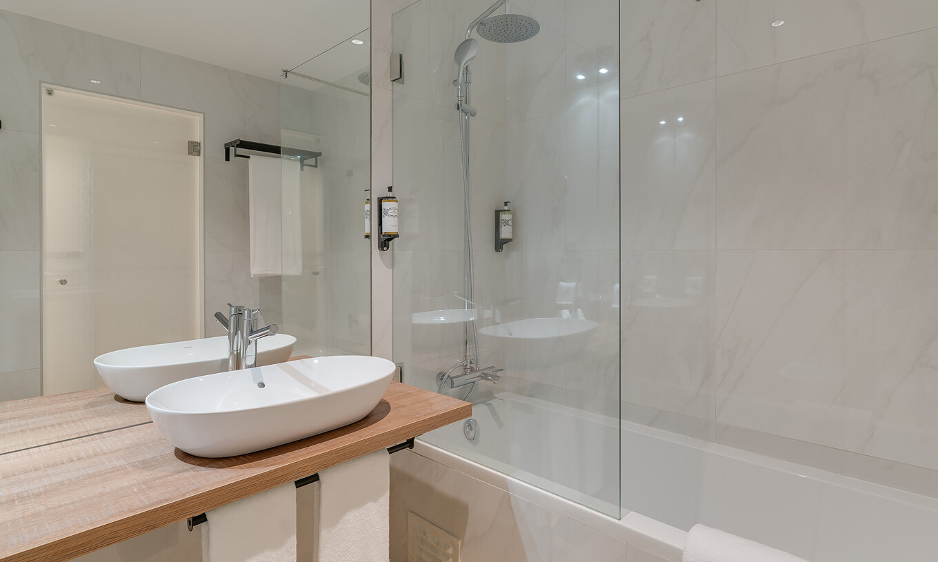 Le Famille - Clubhouse du Pestana Sintra Golf a une salle de bain moderne avec baignoire avec douche et lavabo avec miroir