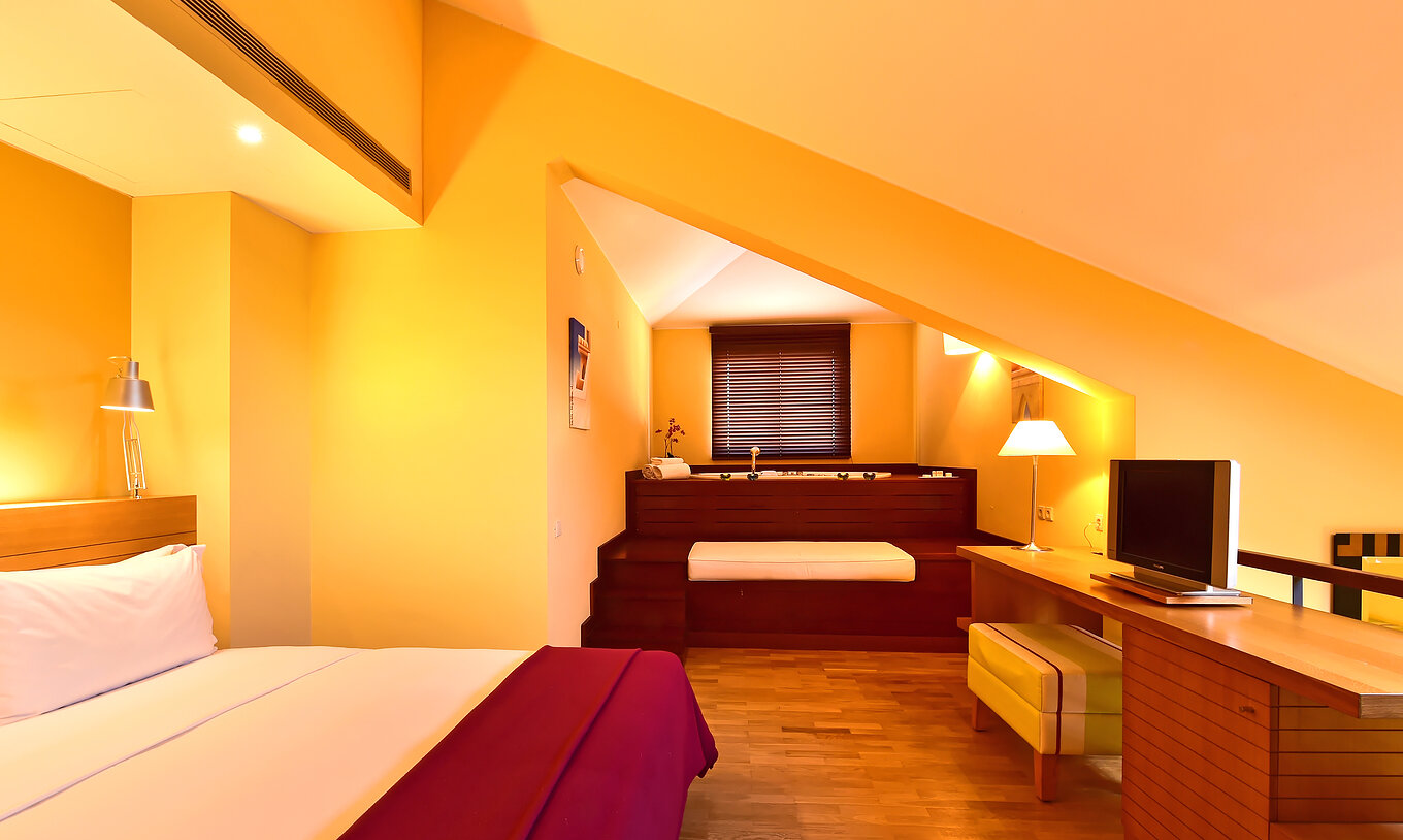 La Suite Mezzanine Jacuzzi du Pestana Sintra Golf a un lit double, jacuzzi dans la chambre et une télévision en face