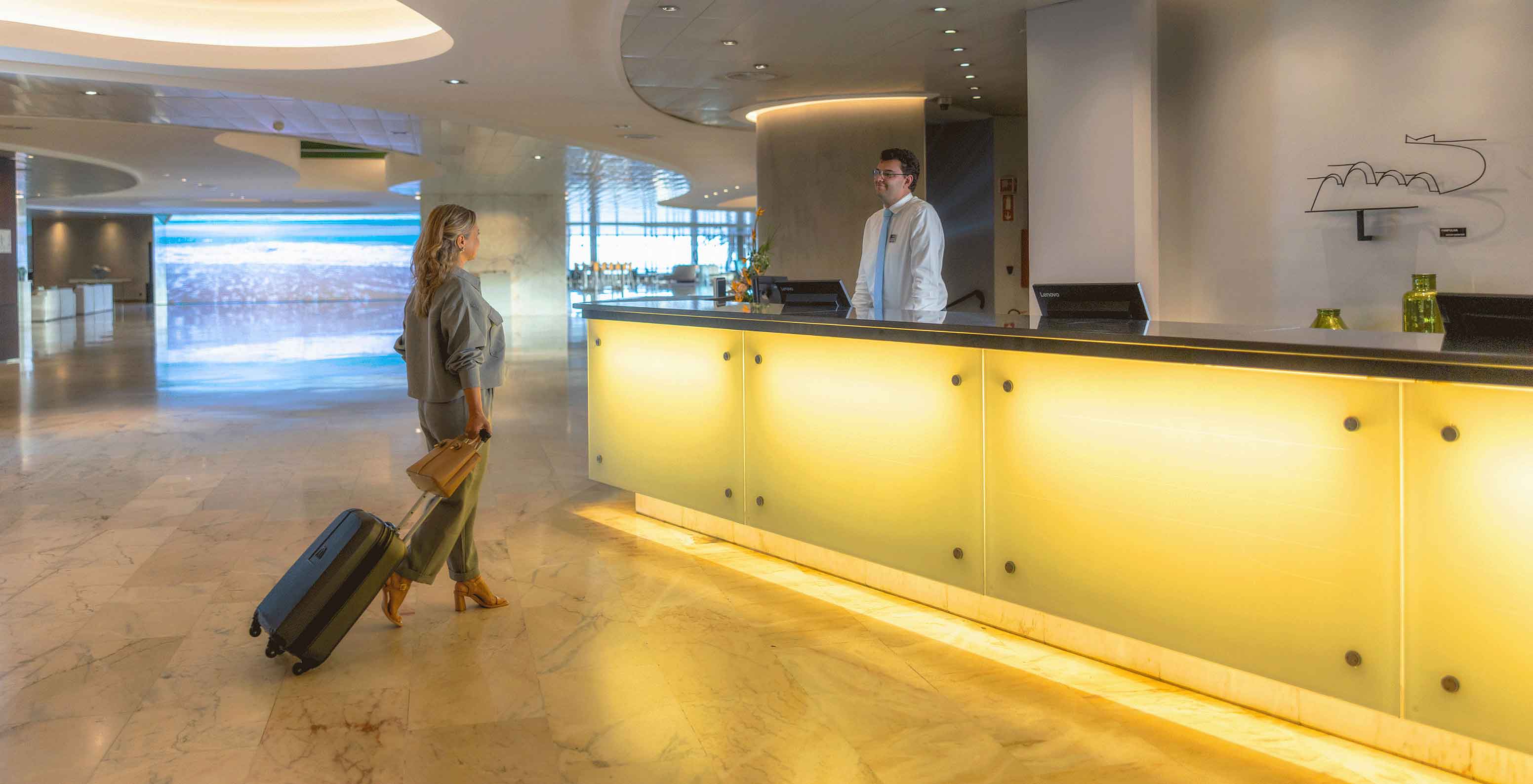 Réception avec membre du personnel souriant au Pestana Casino Park, hôtel à Funchal en bord de mer, avec spa et piscine