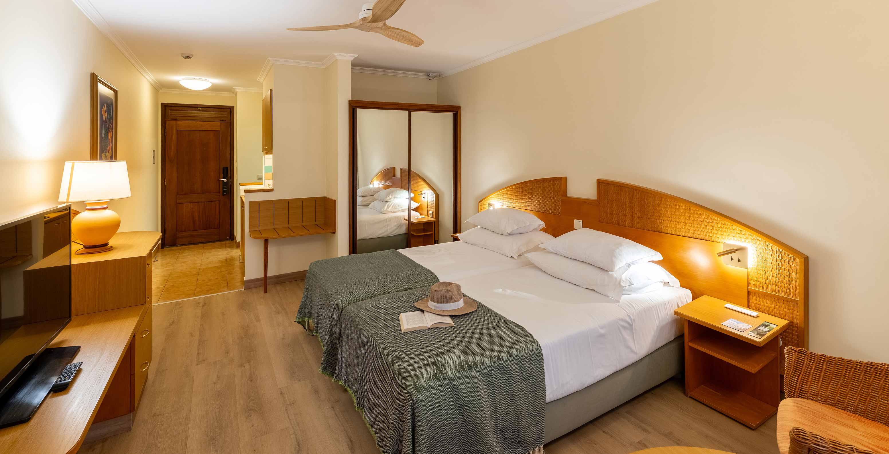 Le Classic Pool View du Pestana Ocean Bay All Inclusive dispose de deux lits simples réunis avec un couvre-lit vert