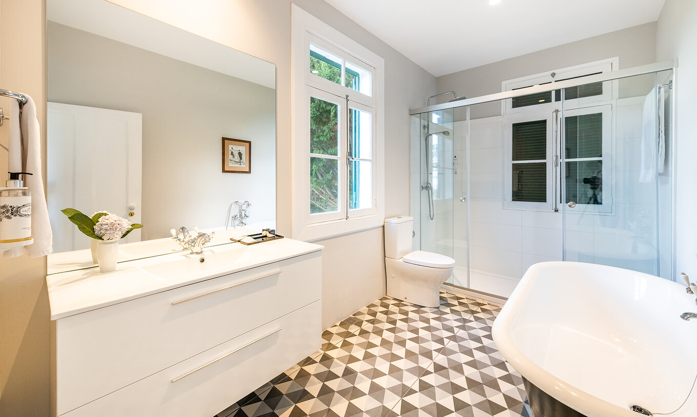 La Maison de Maître - 1 du Pestana Quinta do Arco a salle de bain avec baignoire, lavabo avec grand miroir et fenêtre