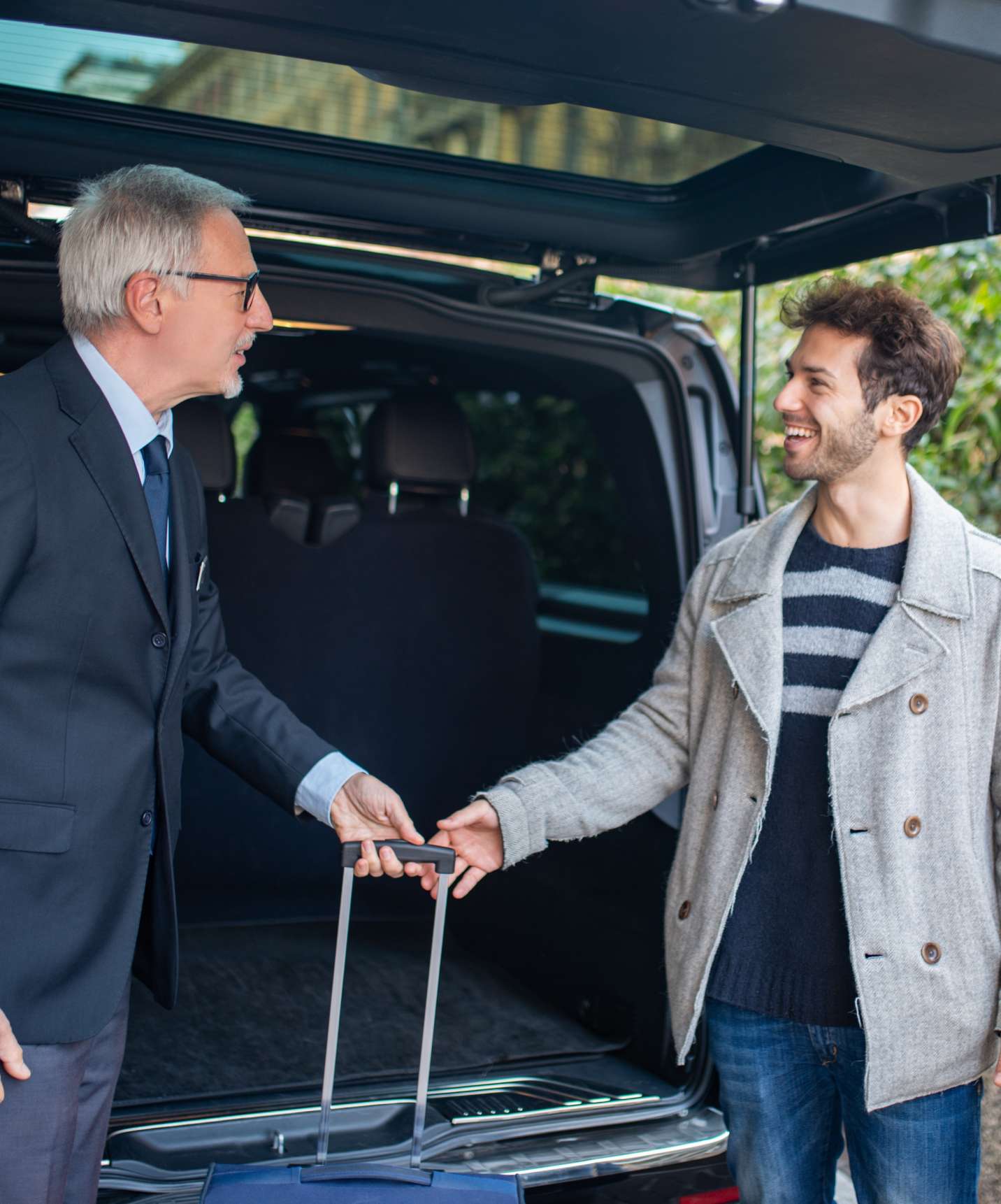 Chauffeur sort les valises du coffre et les remet à un couple arrivant au Quinta Perestrello