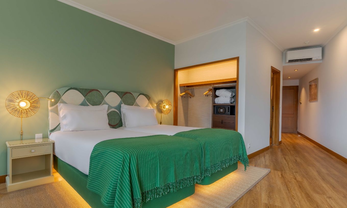 La chambre Supérieure avec Vue Latérale sur la Mer du Pestana Vila Lido Madeira dispose d'un lit double avec une tête de lit verte et une armoire.