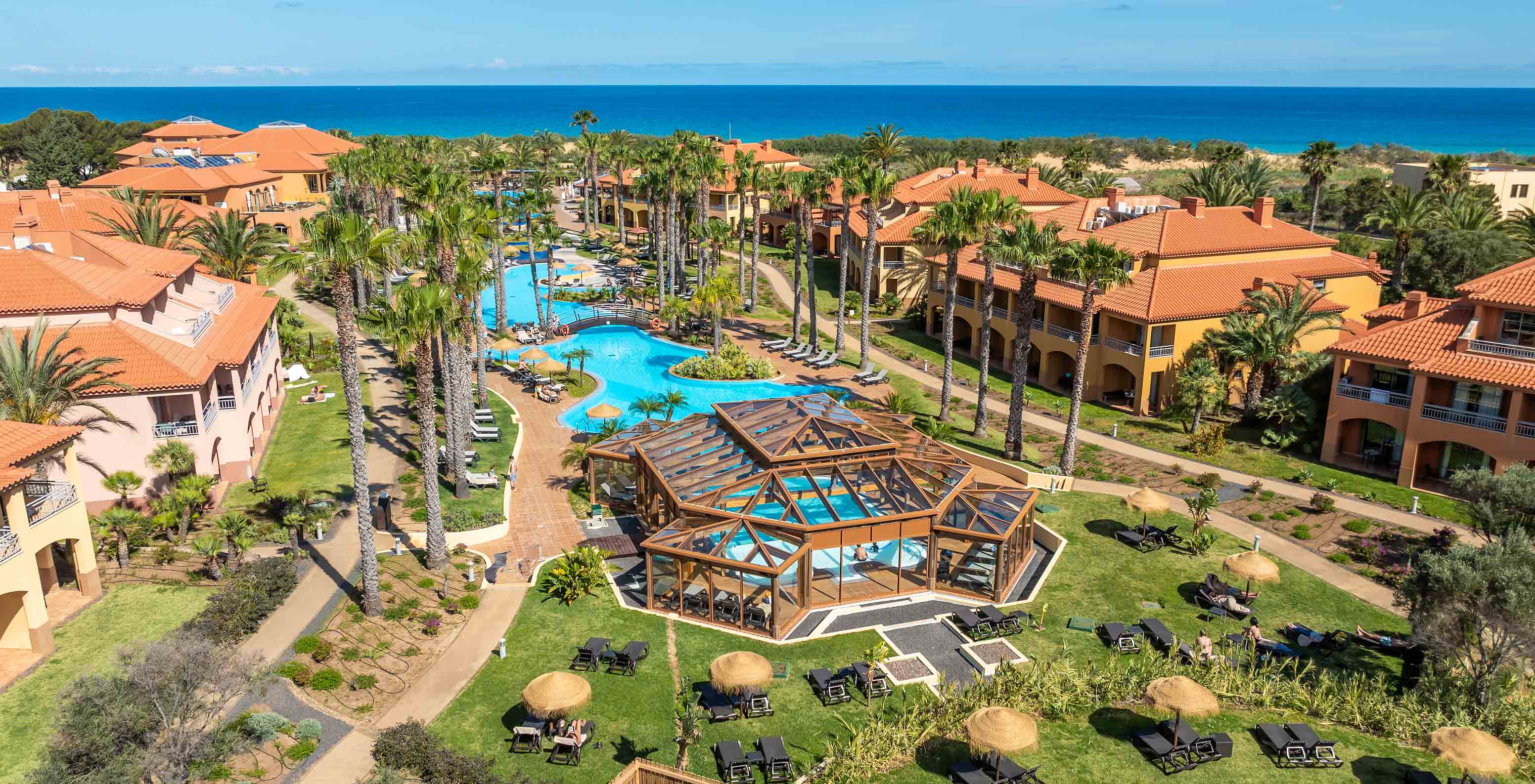 Vue panoramique du Pestana Porto Santo All Inclusive sur la mer, avec le jardin et la piscine entre les villas