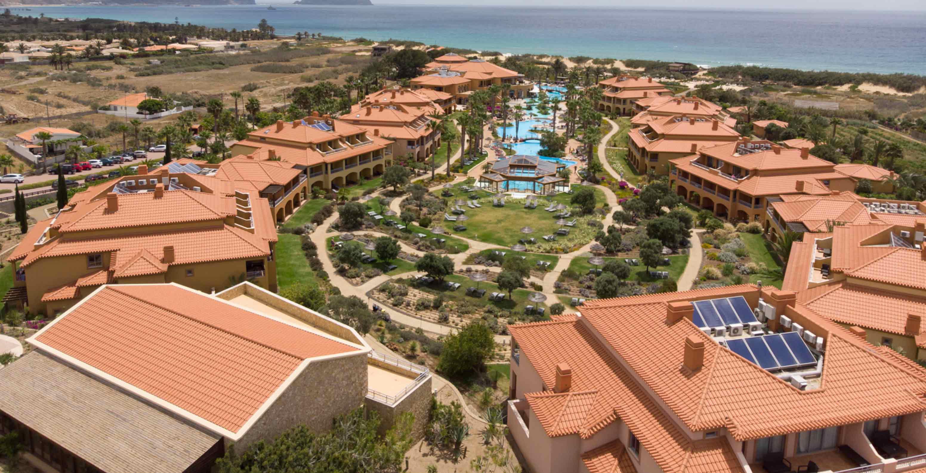 Vue de drone du Pestana Porto Santo All Inclusive, avec plusieurs villas autour de la piscine et de la végétation