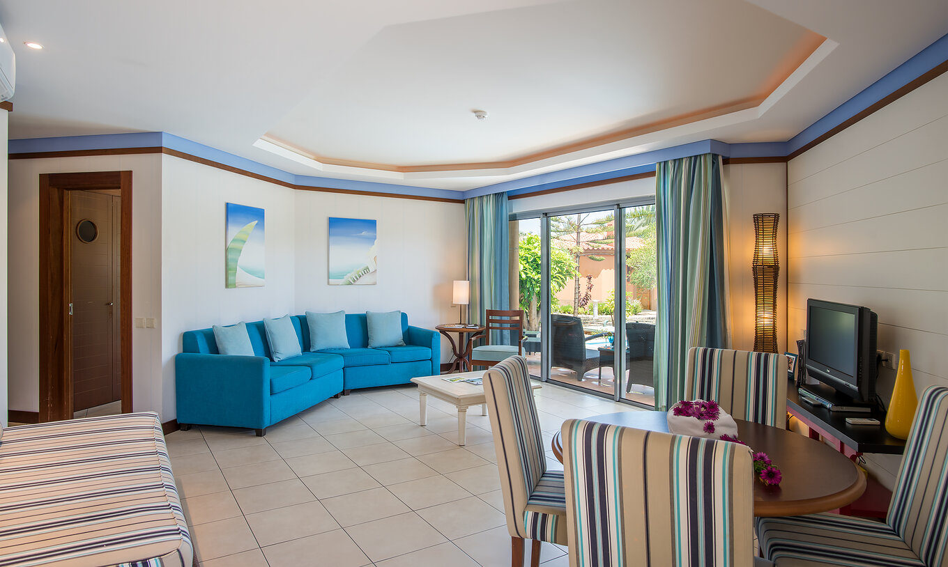 La Pool Villa du Pestana Porto Santo All Inclusive a un salon avec fenêtre, table et chaises, canapé et télévision