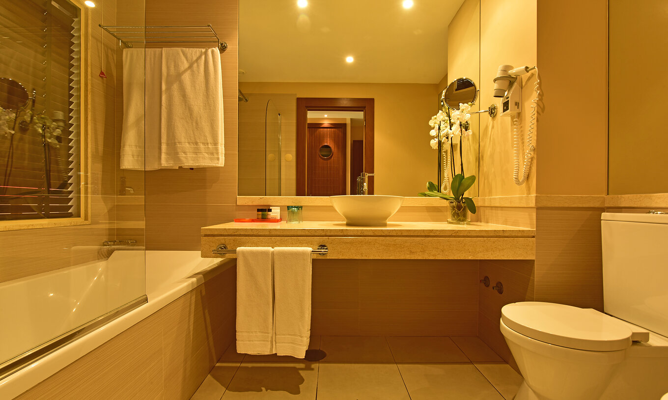 La Suite Appartement T2 du Pestana Porto Santo All Inclusive a une salle de bain avec lavabo, serviettes, miroir et toilettes