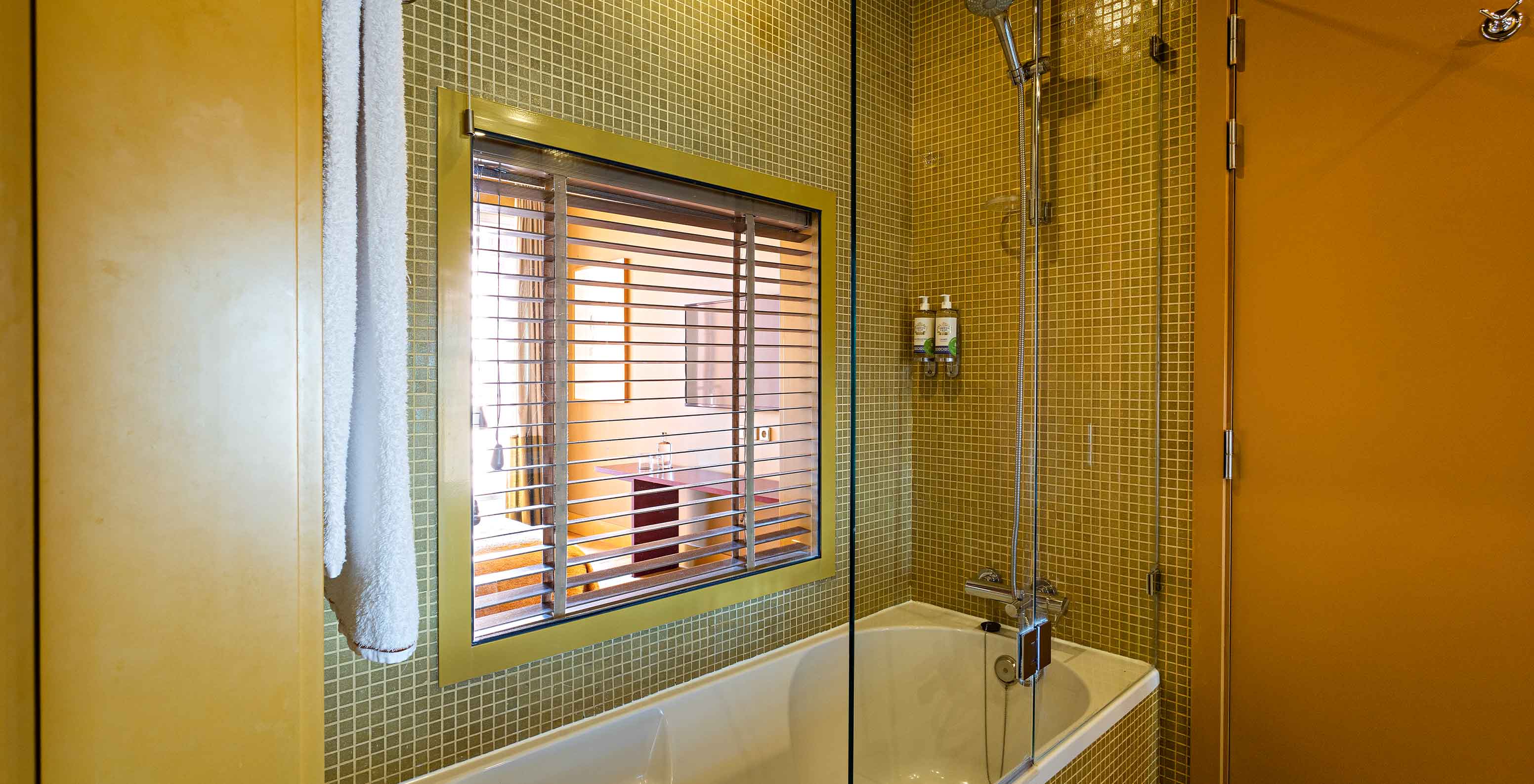 La Suite Balcony comprend une salle de bain avec baignoire et fenêtre sur la chambre