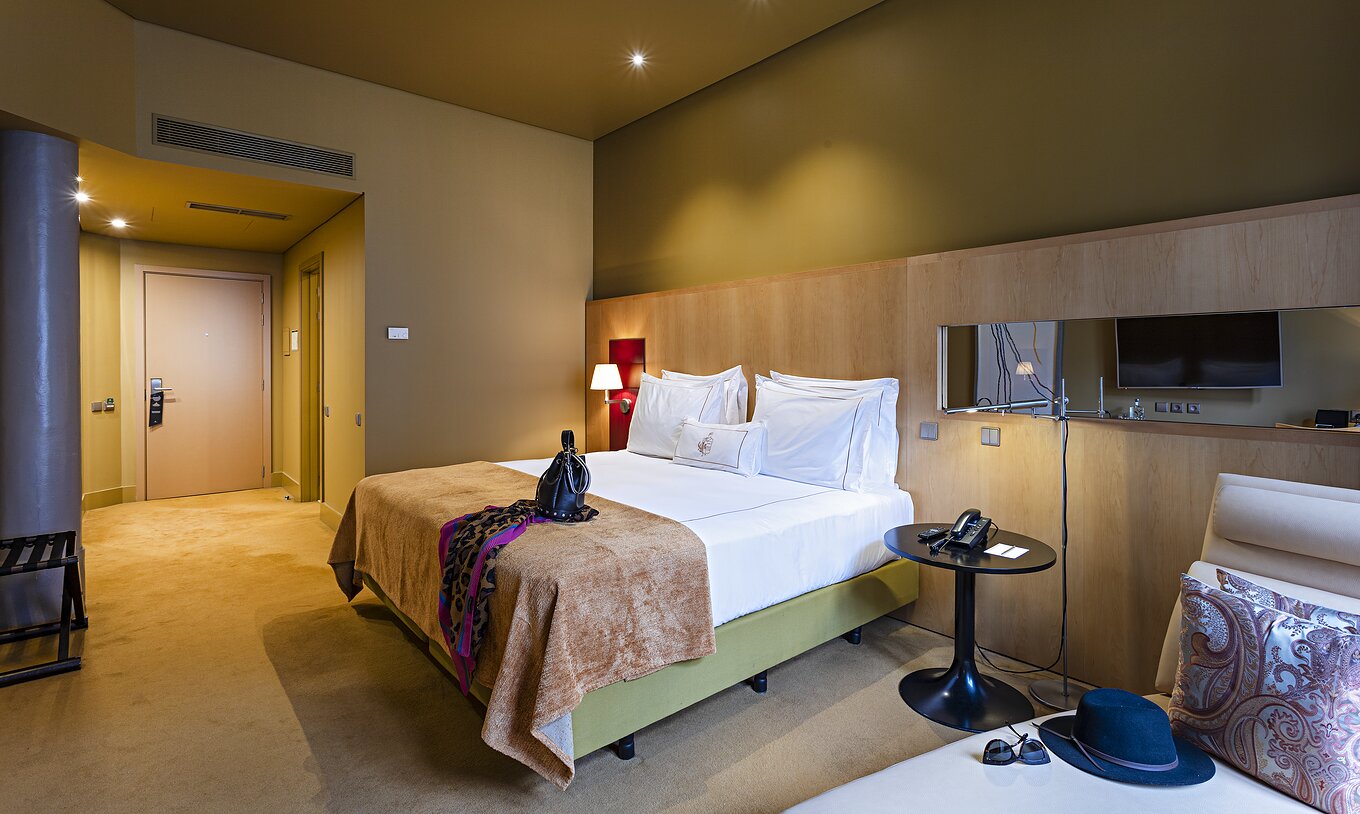 La chambre Classique du Pestana Palácio do Freixo a des murs jaunes, un lit double et un canapé-lit beige