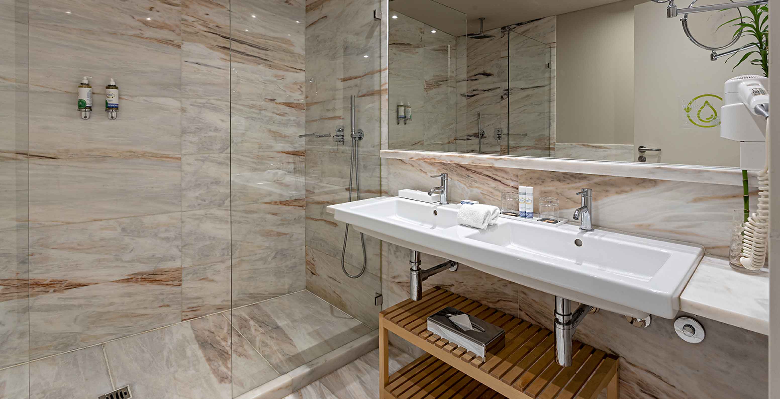 La Heritage Suite du Pestana Vintage Porto dispose d'une salle de bain avec des murs en marbre, un lavabo et une douche