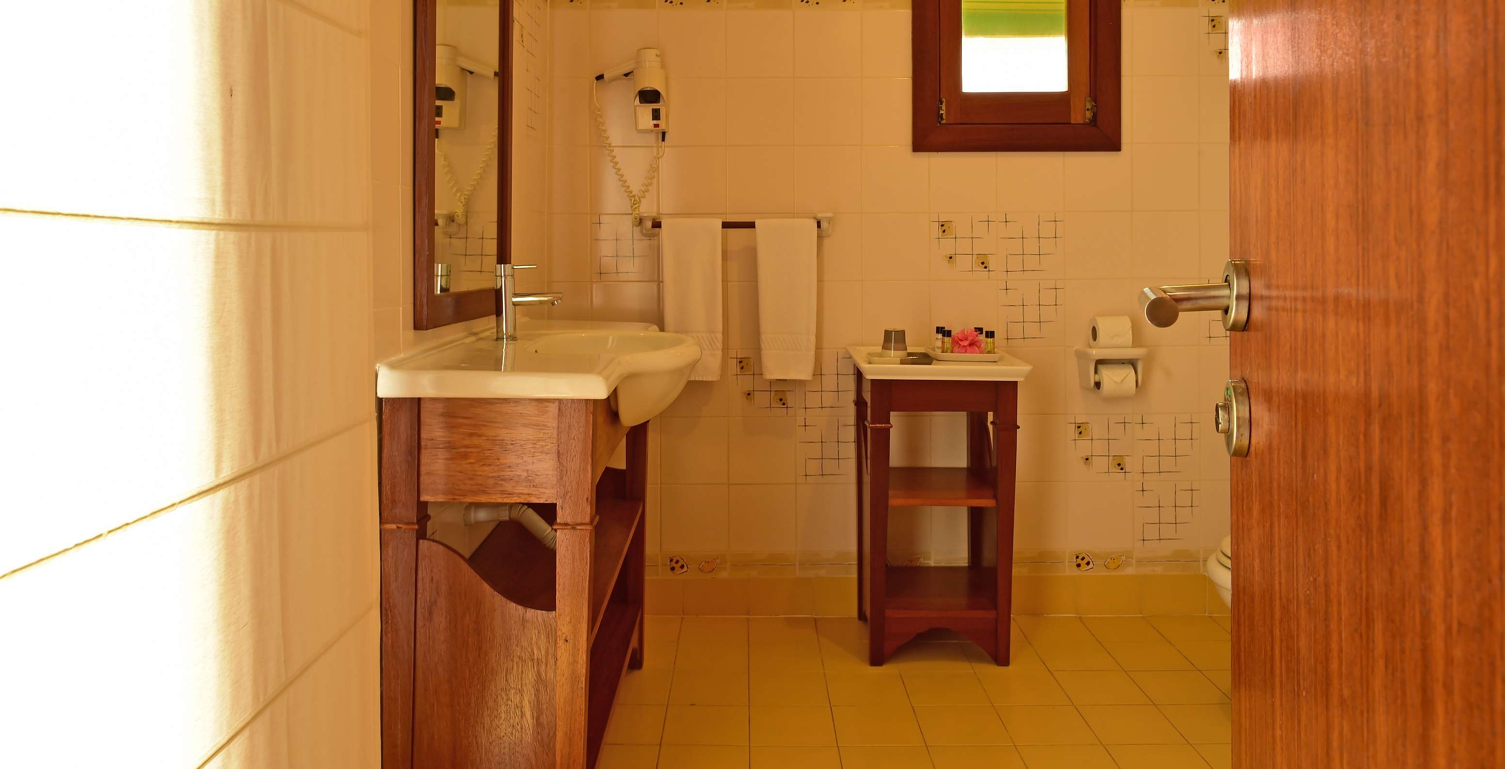 Le Double Supérieur du Pestana Equador Ilheu das Rolas a une salle de bain avec lavabo, miroir, sèche-cheveux et fenêtre