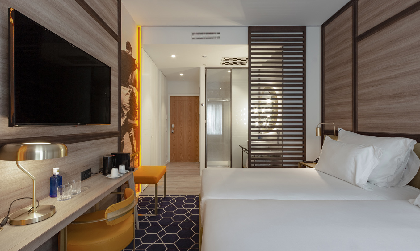 Le Premium avec Vue du Pestana CR7 Gran Vía Madrid a deux lits rapprochés et une séparation en bois pour la salle de bain