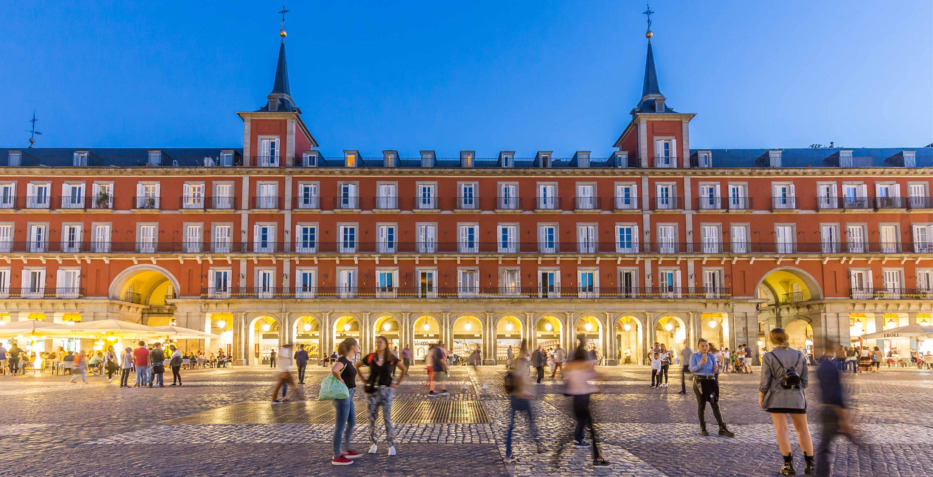 Vue de la façade éclairée du Pestana Collection Plaza Mayor, pendant la nuit, peint en rouge