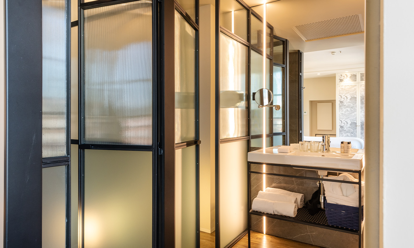 Le Deluxe Grand Plaza Mayor du Pestana Plaza Mayor Madrid a une salle de bain avec lavabo, miroir et serviettes