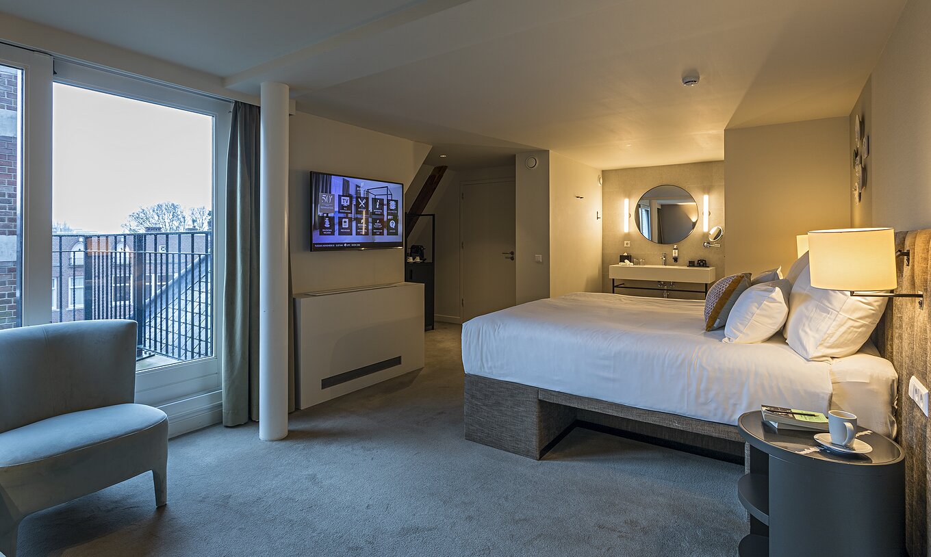 La Presidential Master Suite - Vue Rivière du Pestana Amsterdam Riverside a un lit double et table de nuit