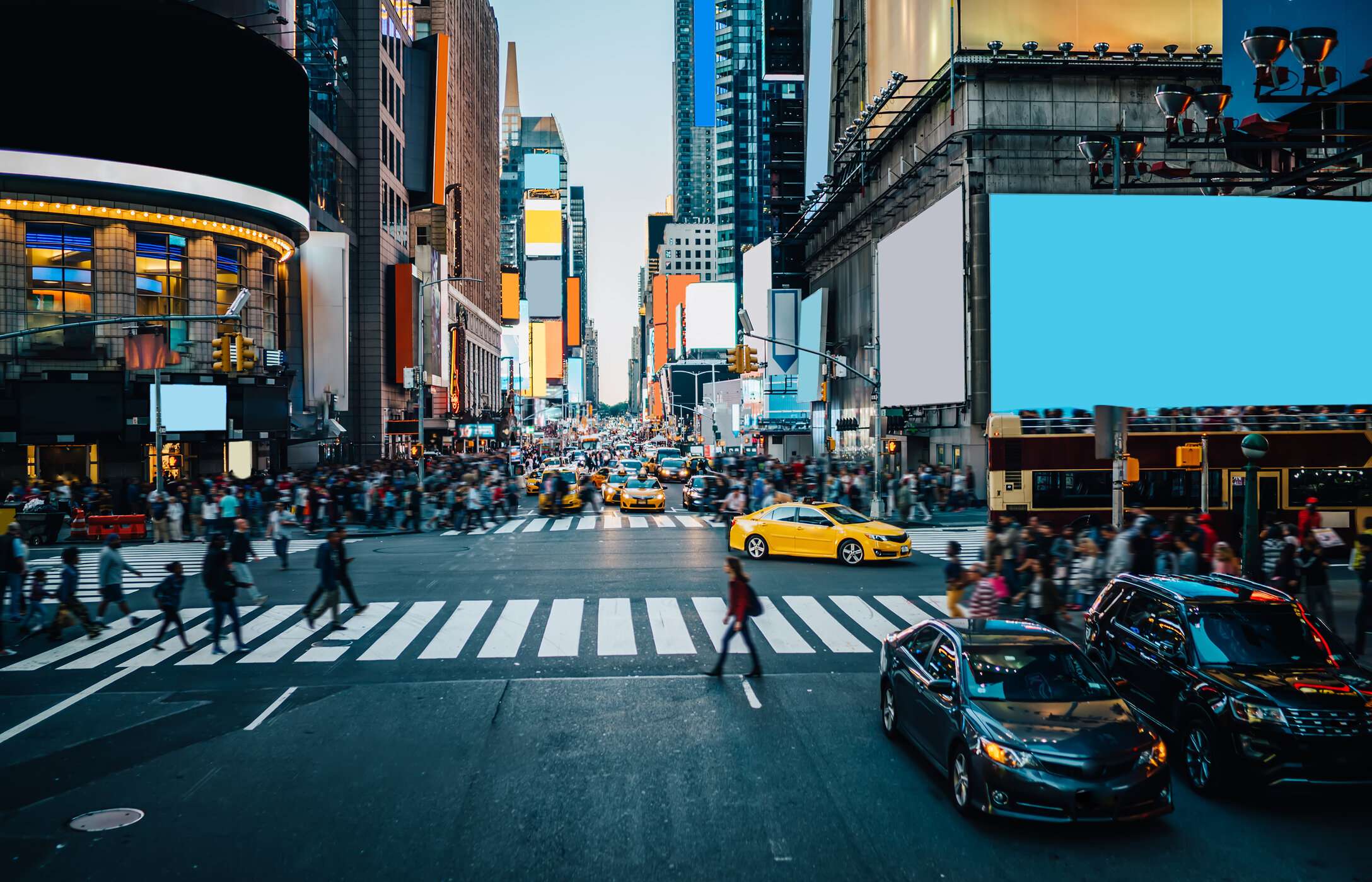 La célèbre Times Square à New York, animée avec voitures et gens, ses écrans géants entourés de hauts bâtiments