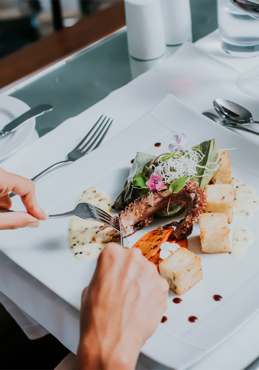 Assiette blanche avec du poulpe et du maïs frit, pendant un repas dans un hôtel de la marque Pestana Hotels and Resorts
