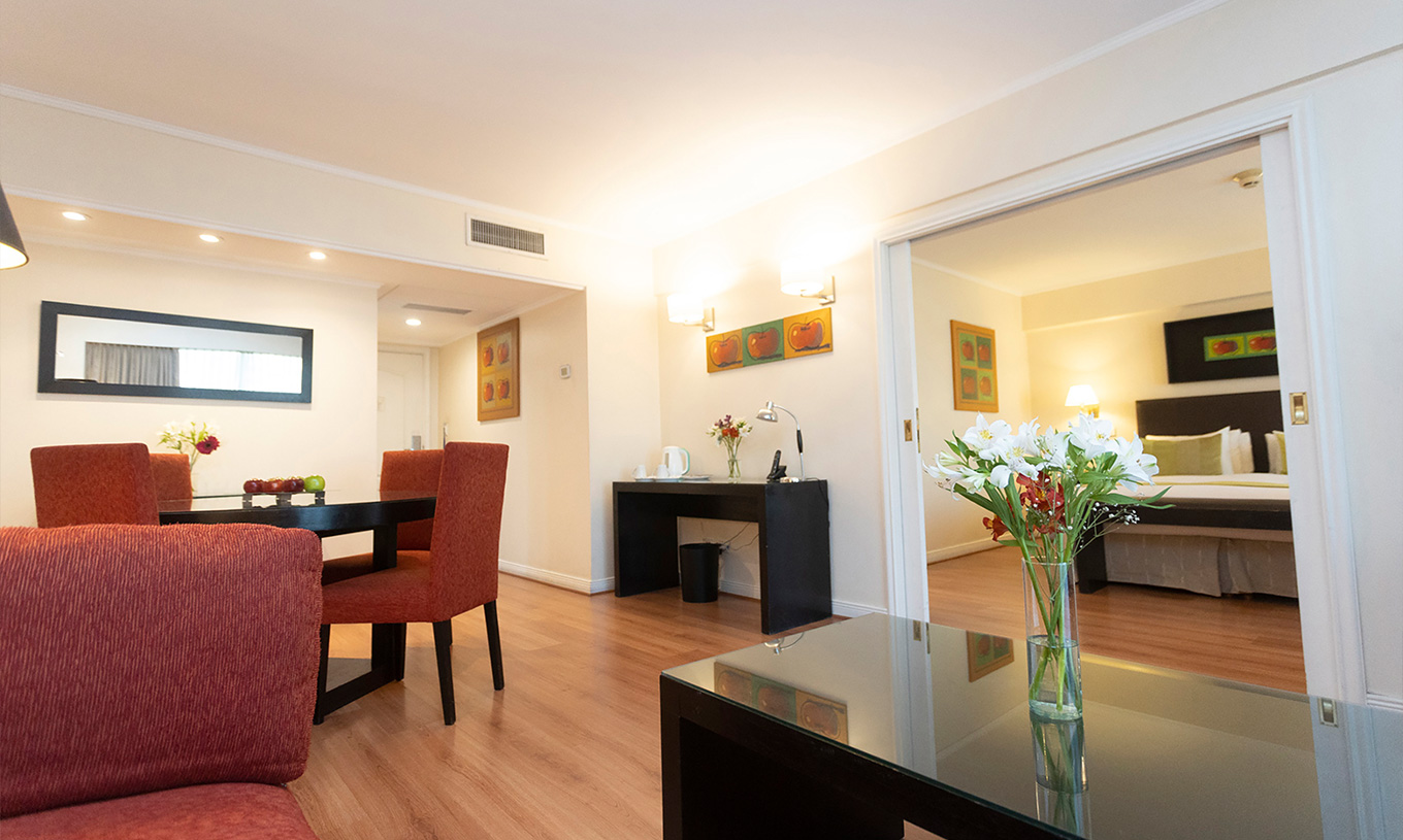 De Queen Suite van Pestana Buenos Aires heeft tafel met stoelen, spiegel, telefoon en salontafel