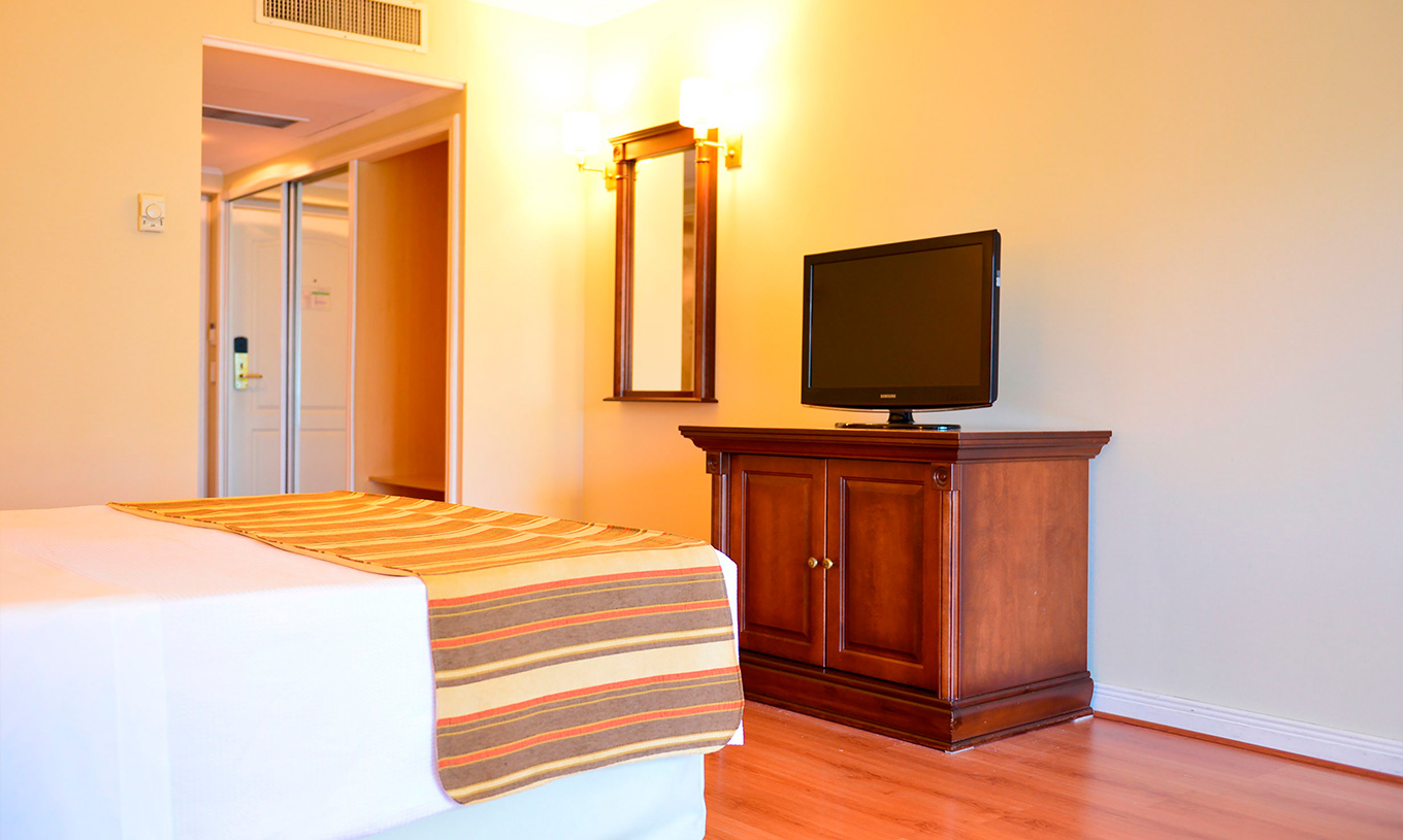 De Twin Deluxe Kamer van Pestana Buenos Aires heeft televisie, kledingkast en spiegel