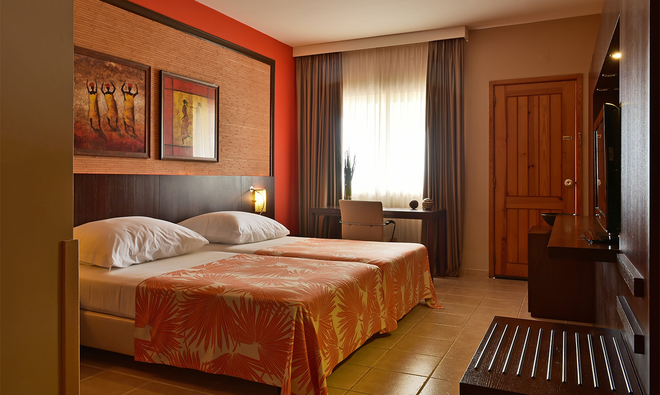 De premium kamer van Pestana Tropico heeft twee eenpersoonsbedden, televisie en bureau met stoel