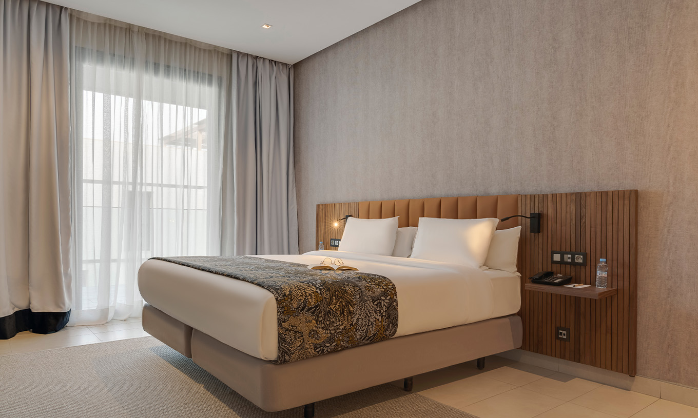 De Premium Familiale Superior Suite van Pestana Casablanca heeft een slaapsuite met een tweepersoonsbed en moderne decoratie
