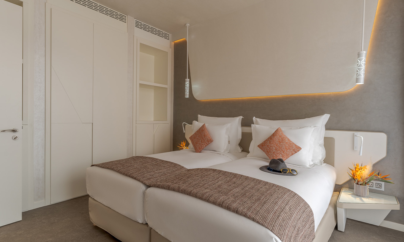 De CR7 Suite Avenue van Pestana CR7 Marrakech heeft een kamer met twee eenpersoonsbedden, nachtkastjes en kasten